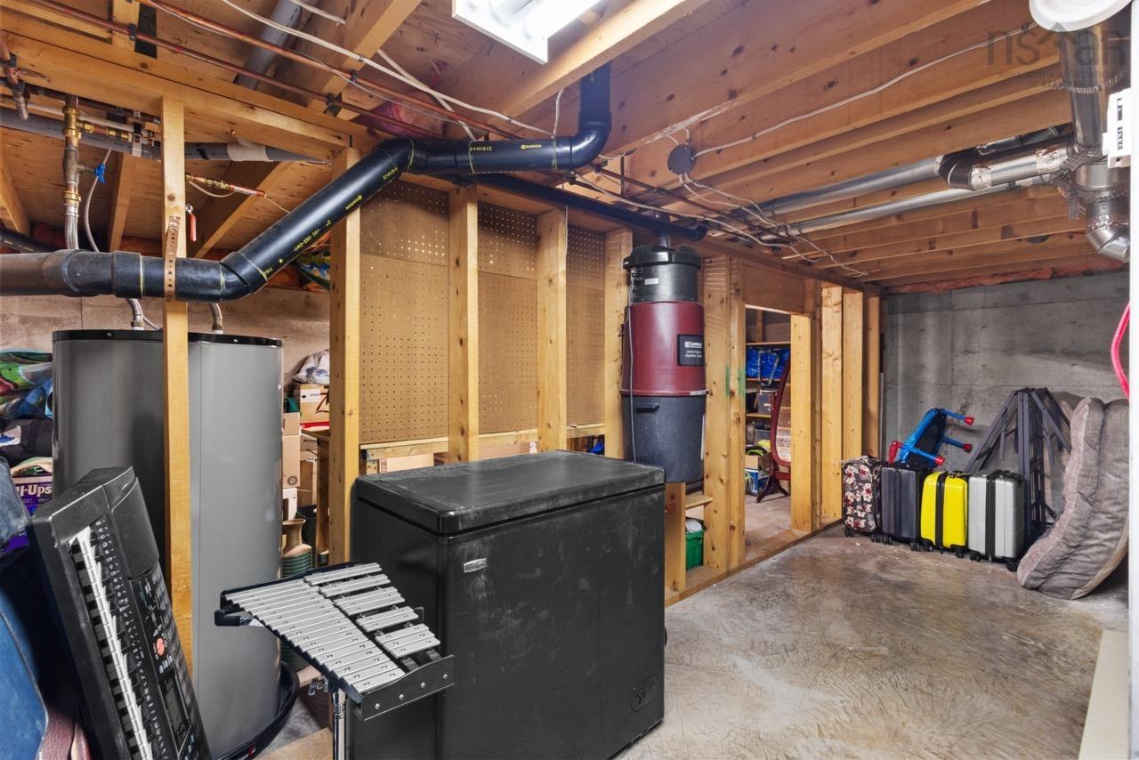 24 Rossi Drive, Dartmouth, NS (MLS® 202626410) — Unfinished utility space featuring exposed wood-stud framing, concrete flooring, dedicated water heater, and a central vacuum system