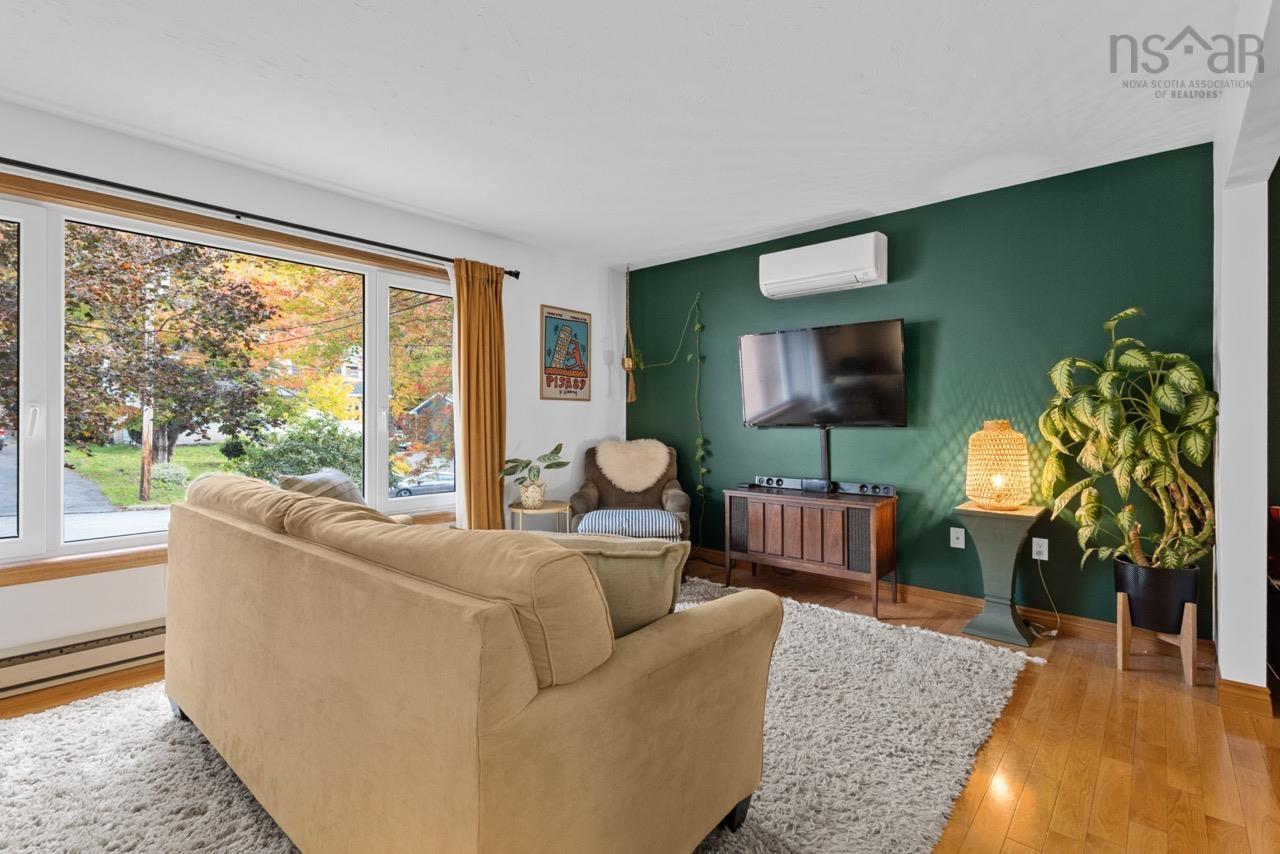 24 Rossi Drive, Dartmouth, NS (MLS® 202626410) — Living space featuring large windows, wood-finish flooring, and a wall-mounted ductless heating and cooling unit