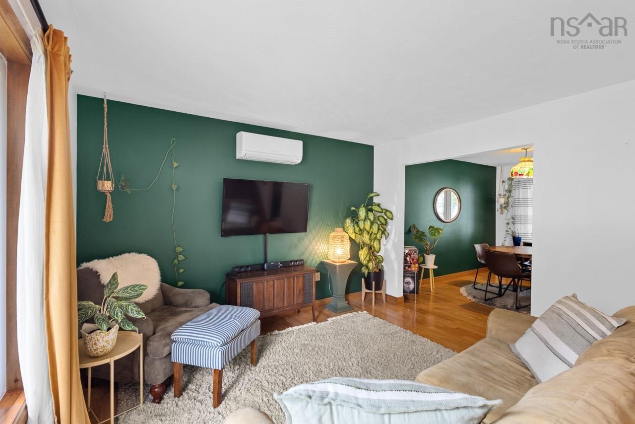 24 Rossi Drive, Dartmouth, NS (MLS® 202626410) — Living space featuring wood-finish flooring, a wall-mounted ductless mini-split system, and a deep green accent wall