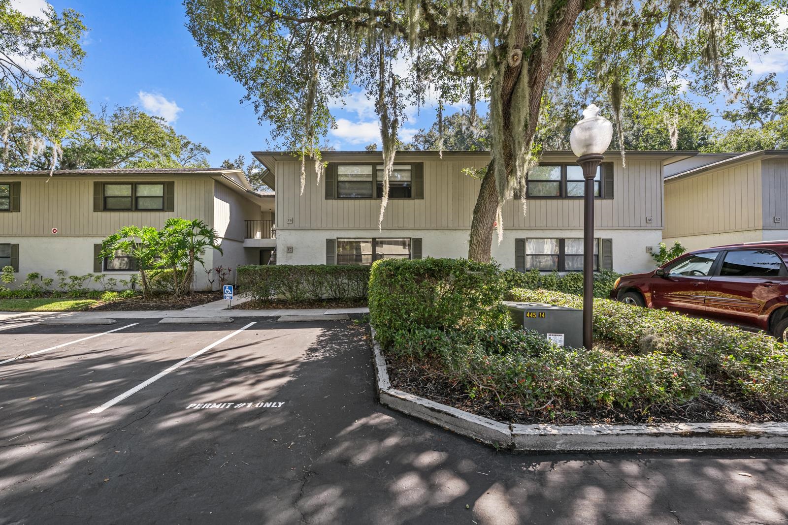 View of building exterior featuring parking community pool is cross the parking lot FIRST FLOOR UNIT