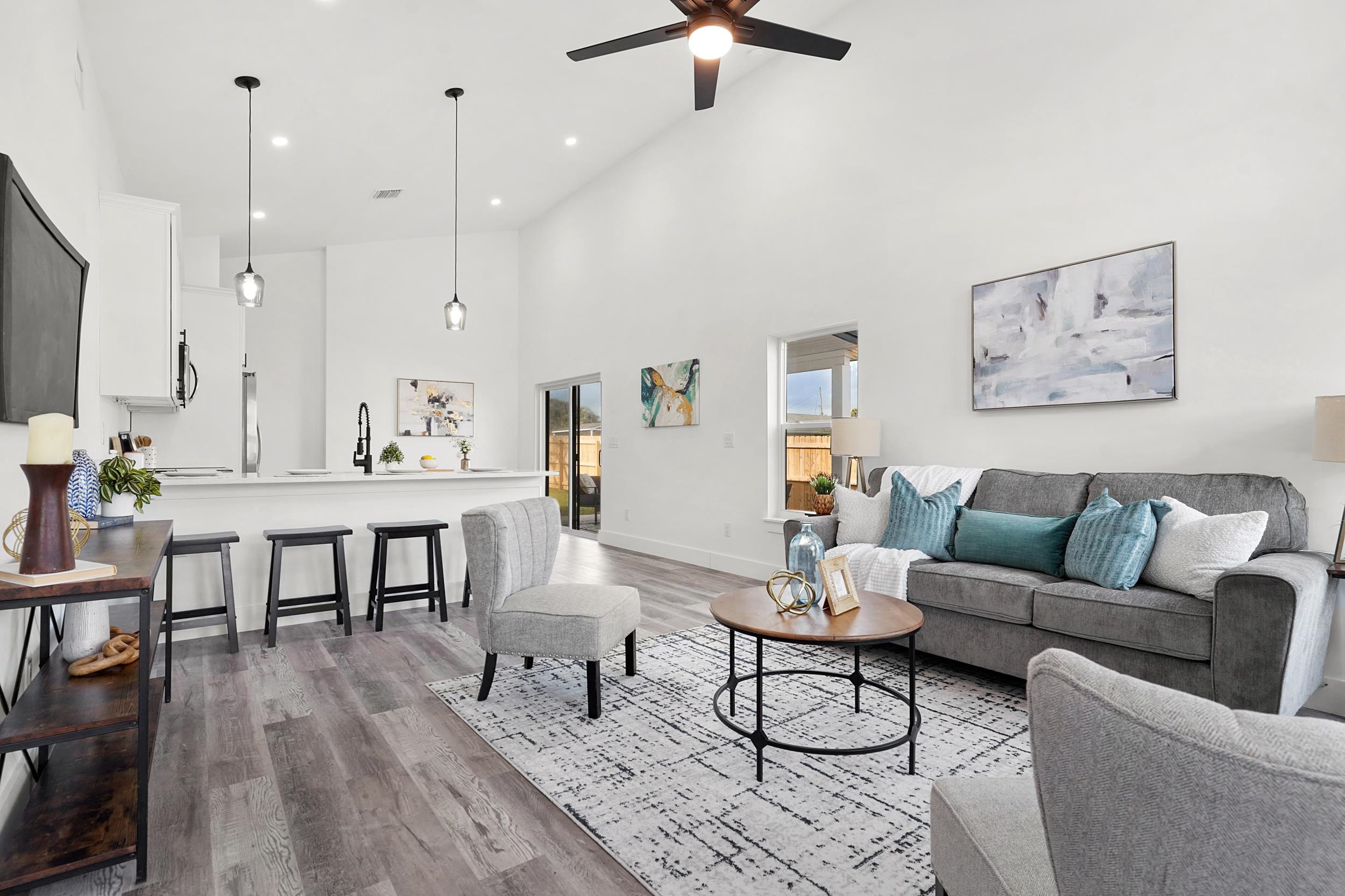 Living area featuring dark wood-type flooring, a high ceiling, and ceiling fan *photos from model next door and ai generated*