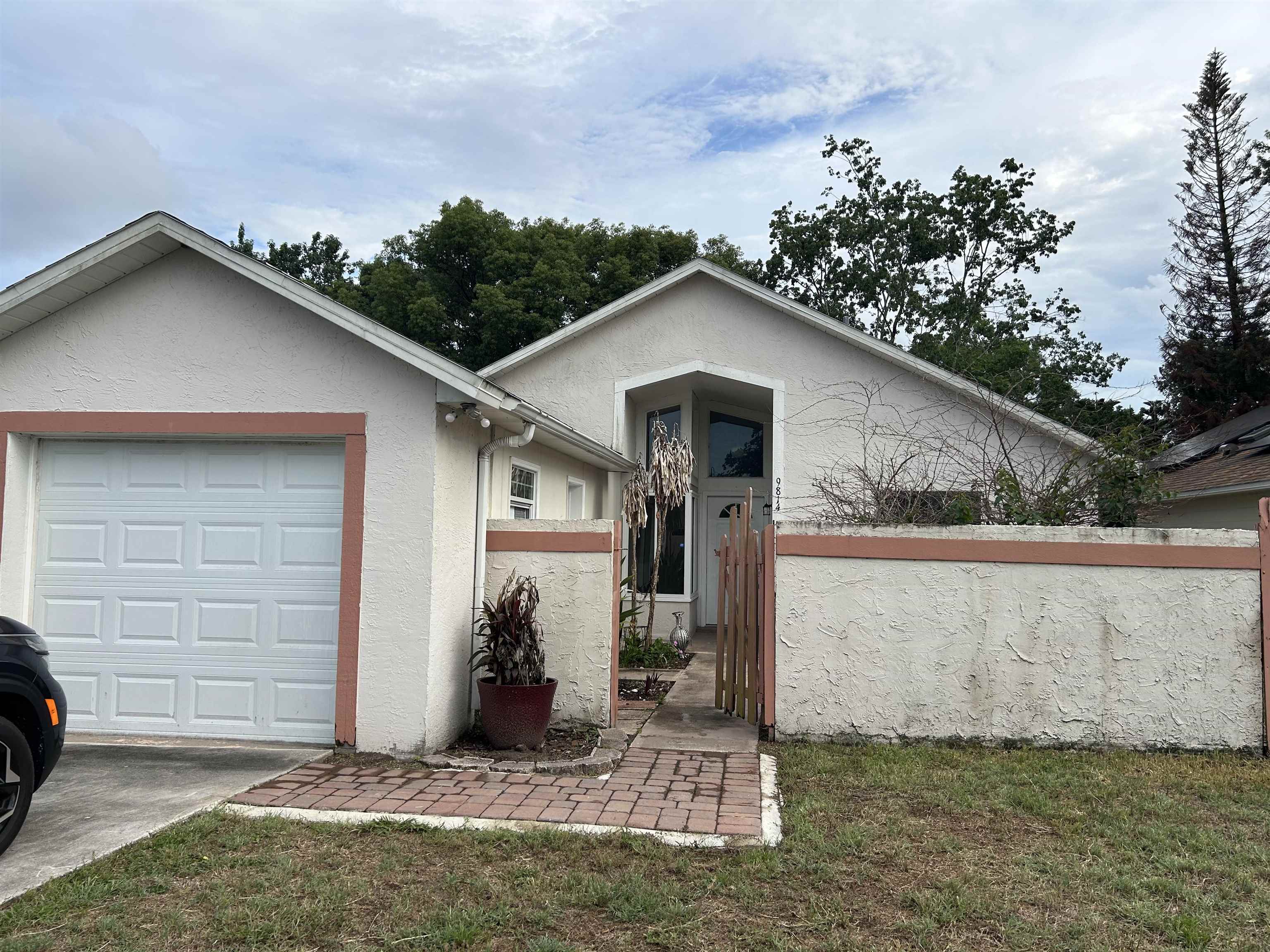 Stucco exterior with a peaked roofline and front-facing garage Front Of Structure