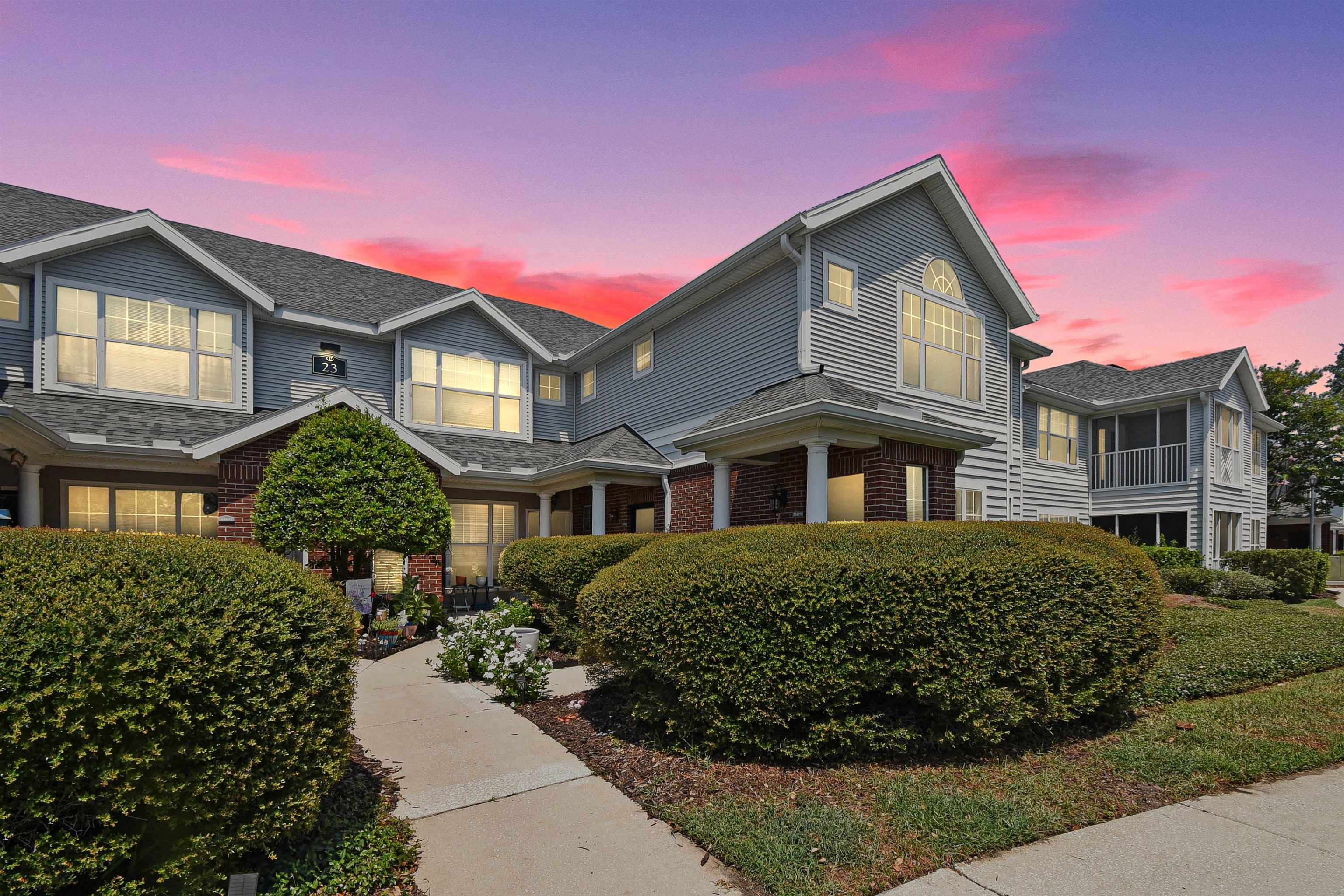 Multi-level residence featuring light blue siding, brick accents, and a dark shingle roof Front Of Structure