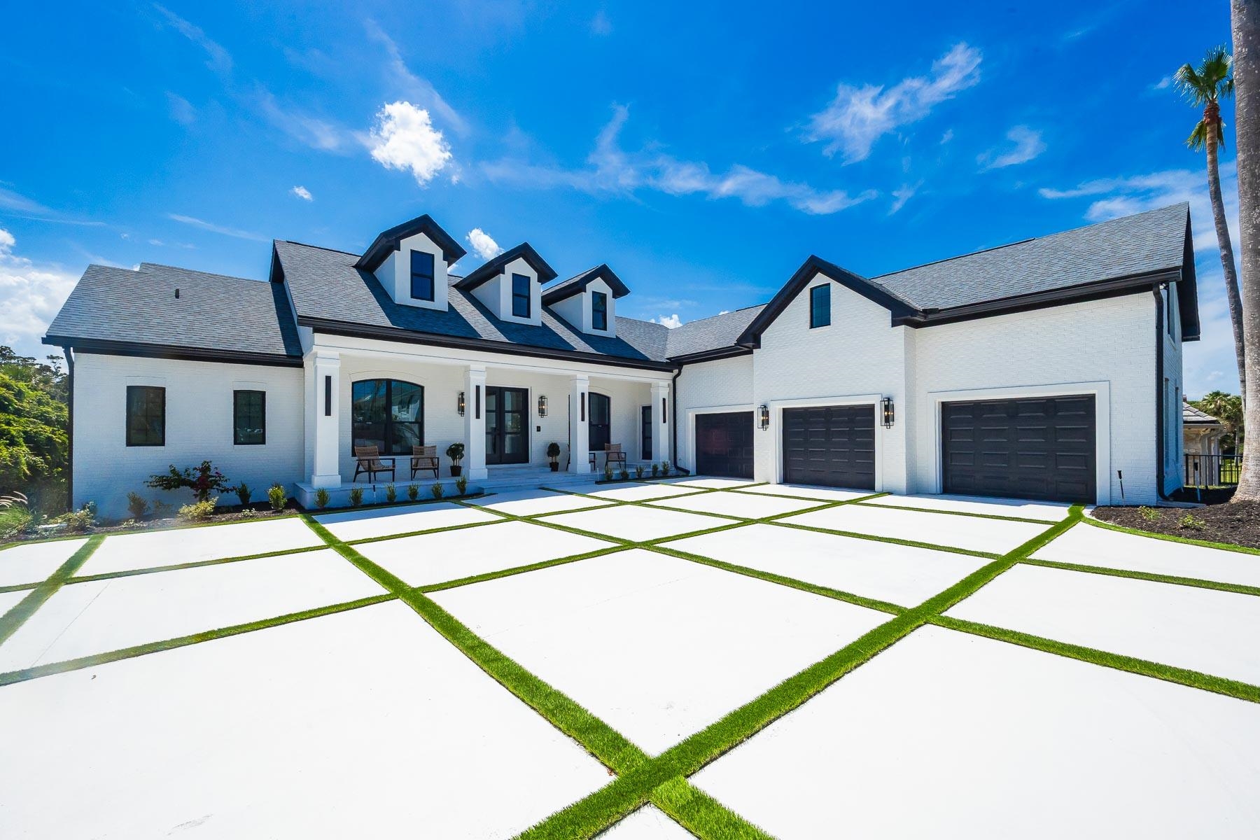 Contemporary white brick exterior with a dark gray shingle roof and black trim Front Of Structure