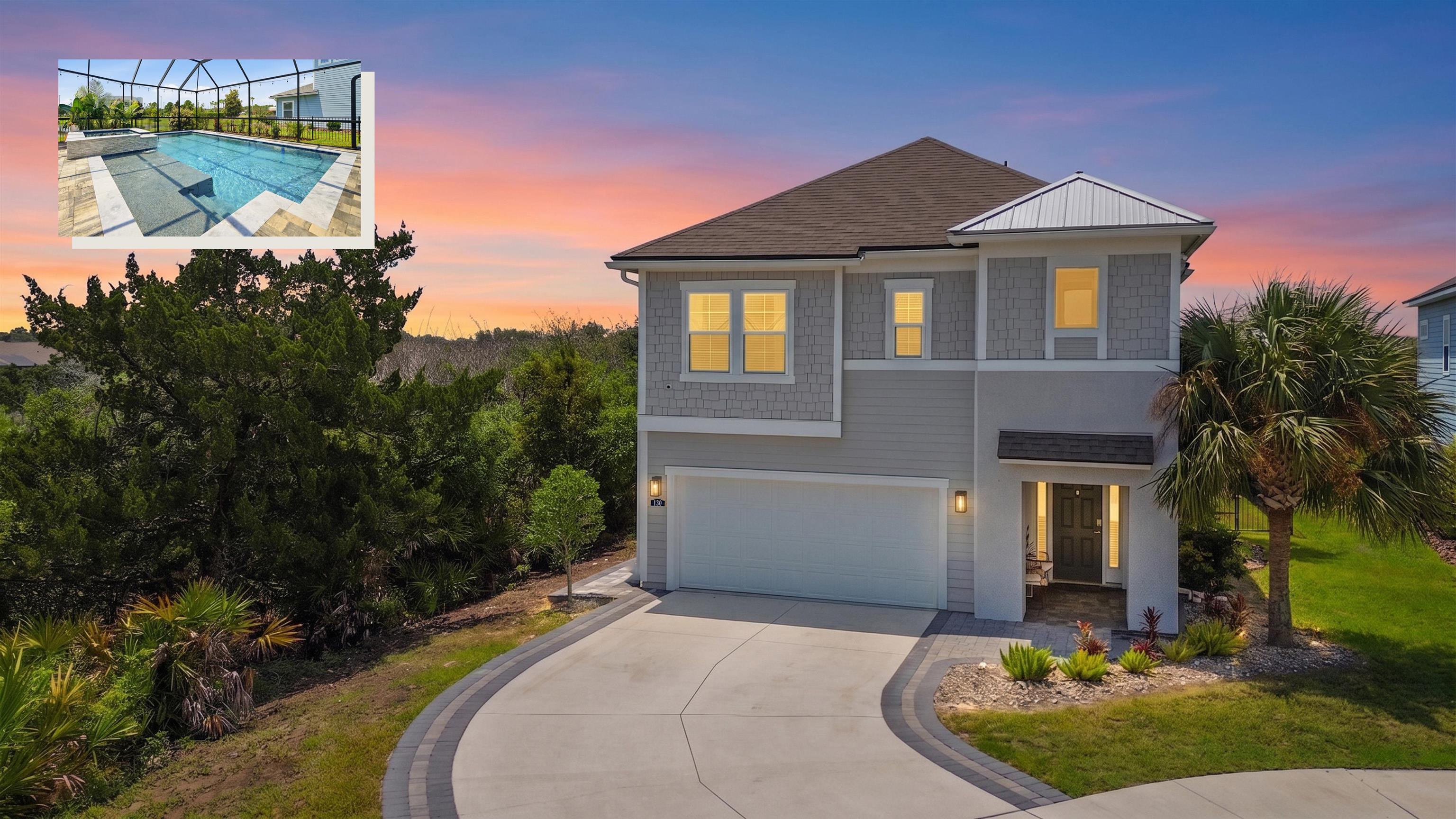 Modern two-story residence with a covered entry, an attached garage, and a paver-lined driveway Front Of Structure