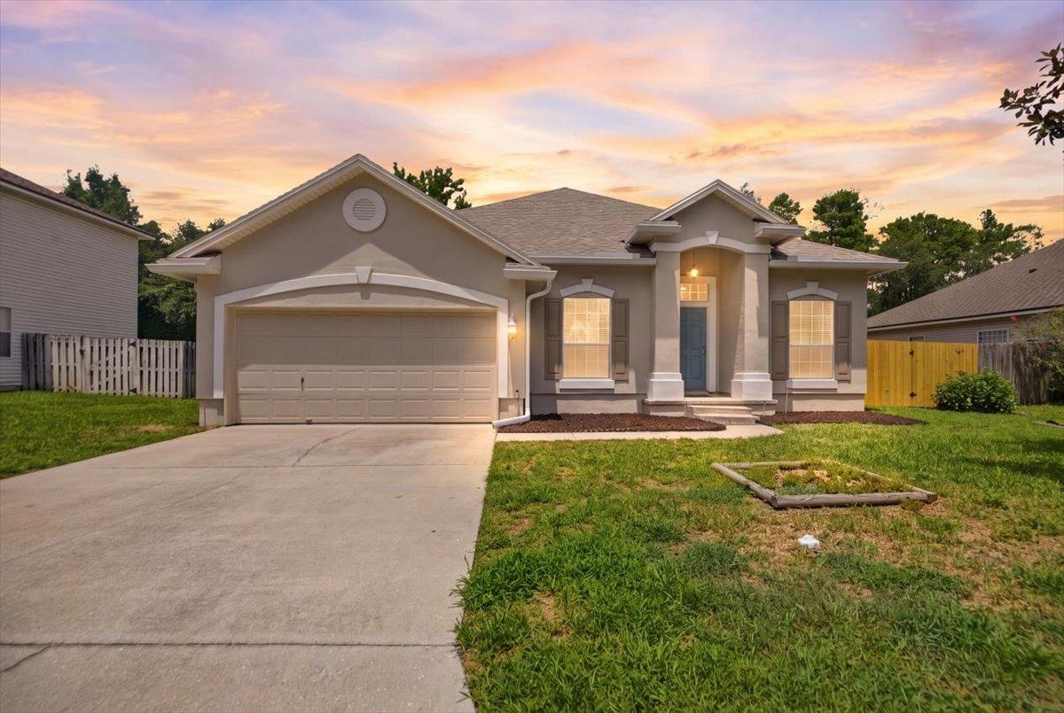 Stucco exterior with a covered entry, two-car garage, and concrete driveway Front Of Structure