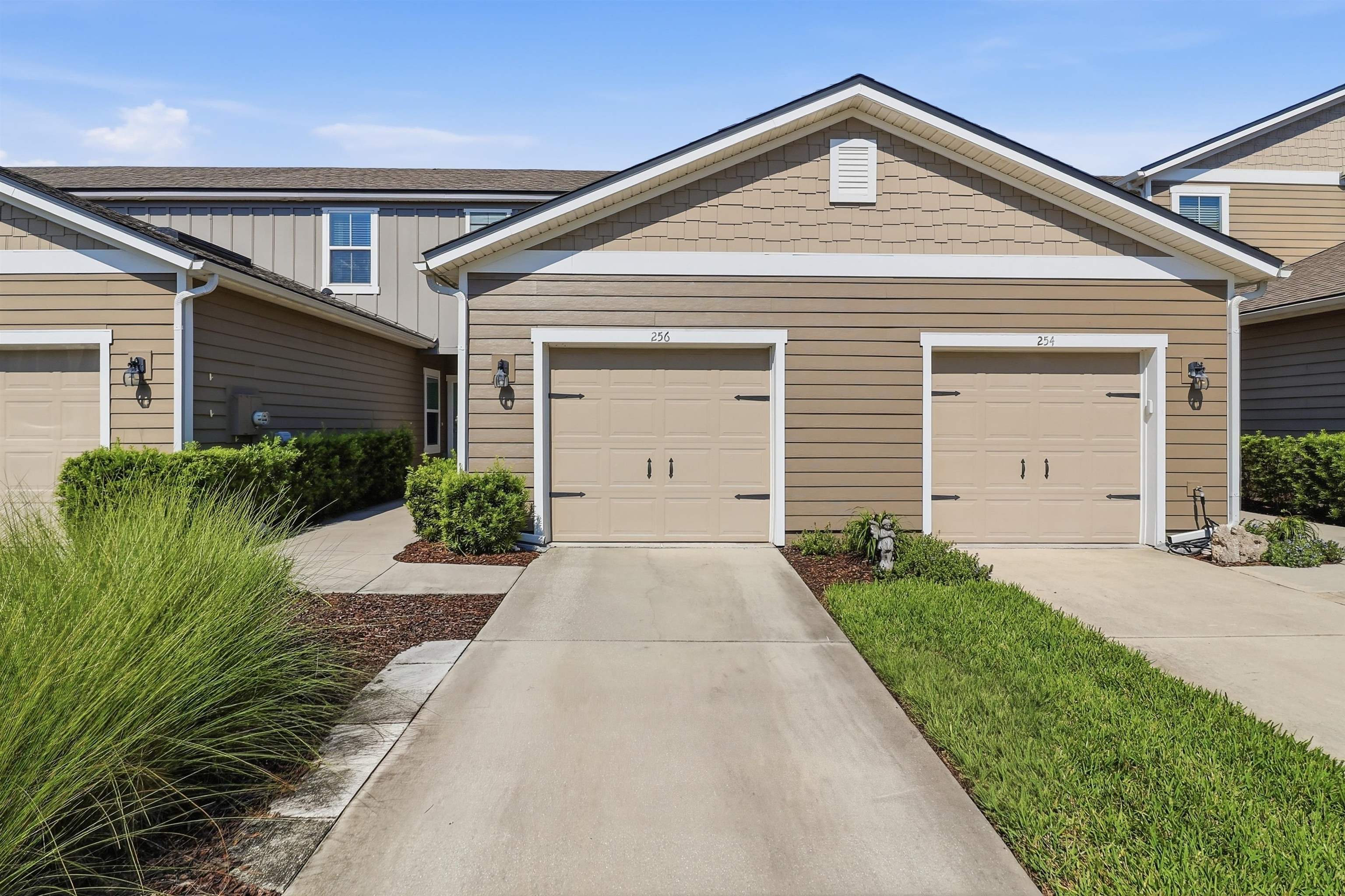 Two-car garage with carriage-style doors, durable siding exterior, and well-maintained landscaping Front Of Structure