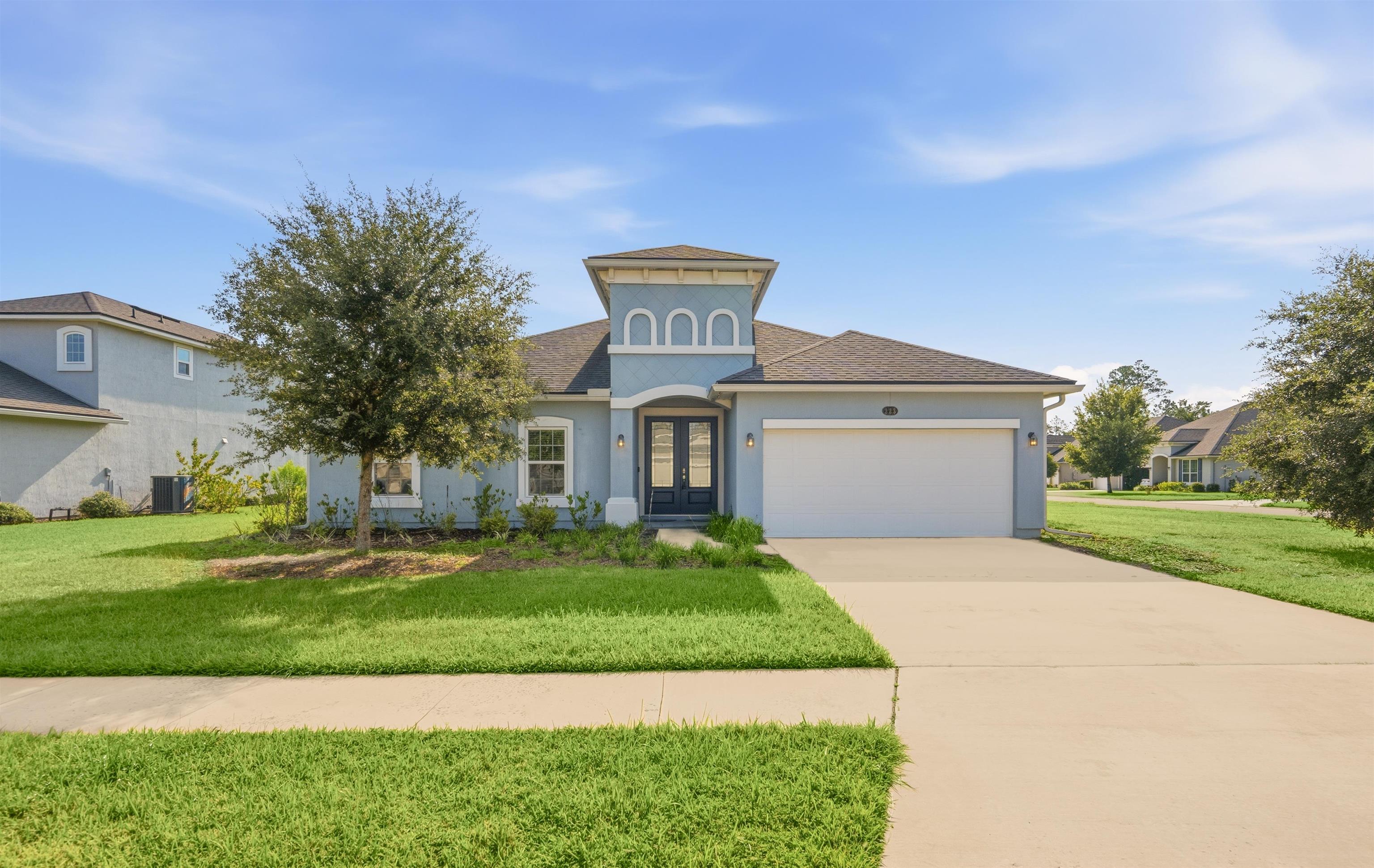 Contemporary stucco exterior with a prominent arched entry feature Front Of Structure