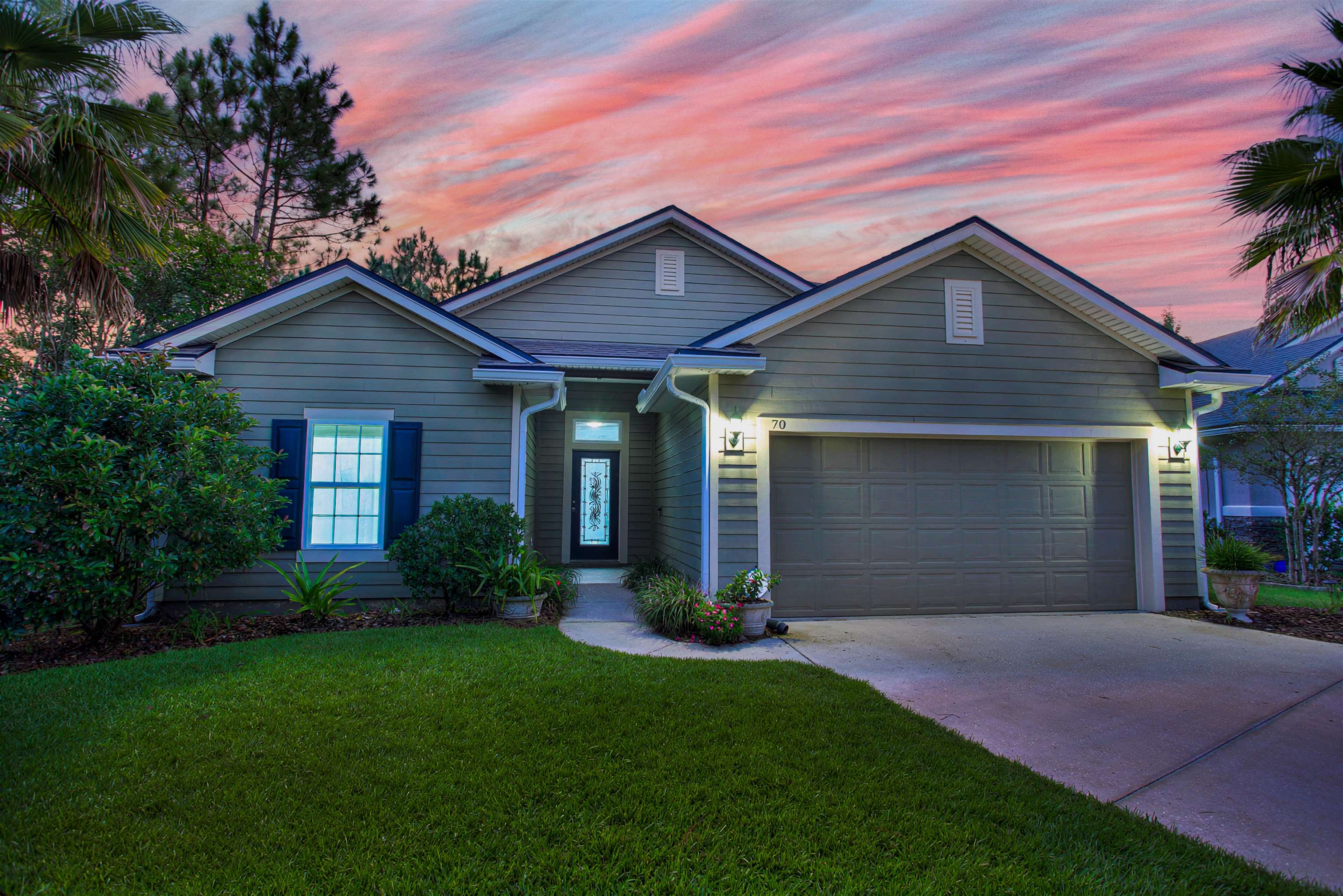 Exterior featuring horizontal siding, a two-car garage, a concrete driveway, and a front entry with a decorative glass door Front Of Structure