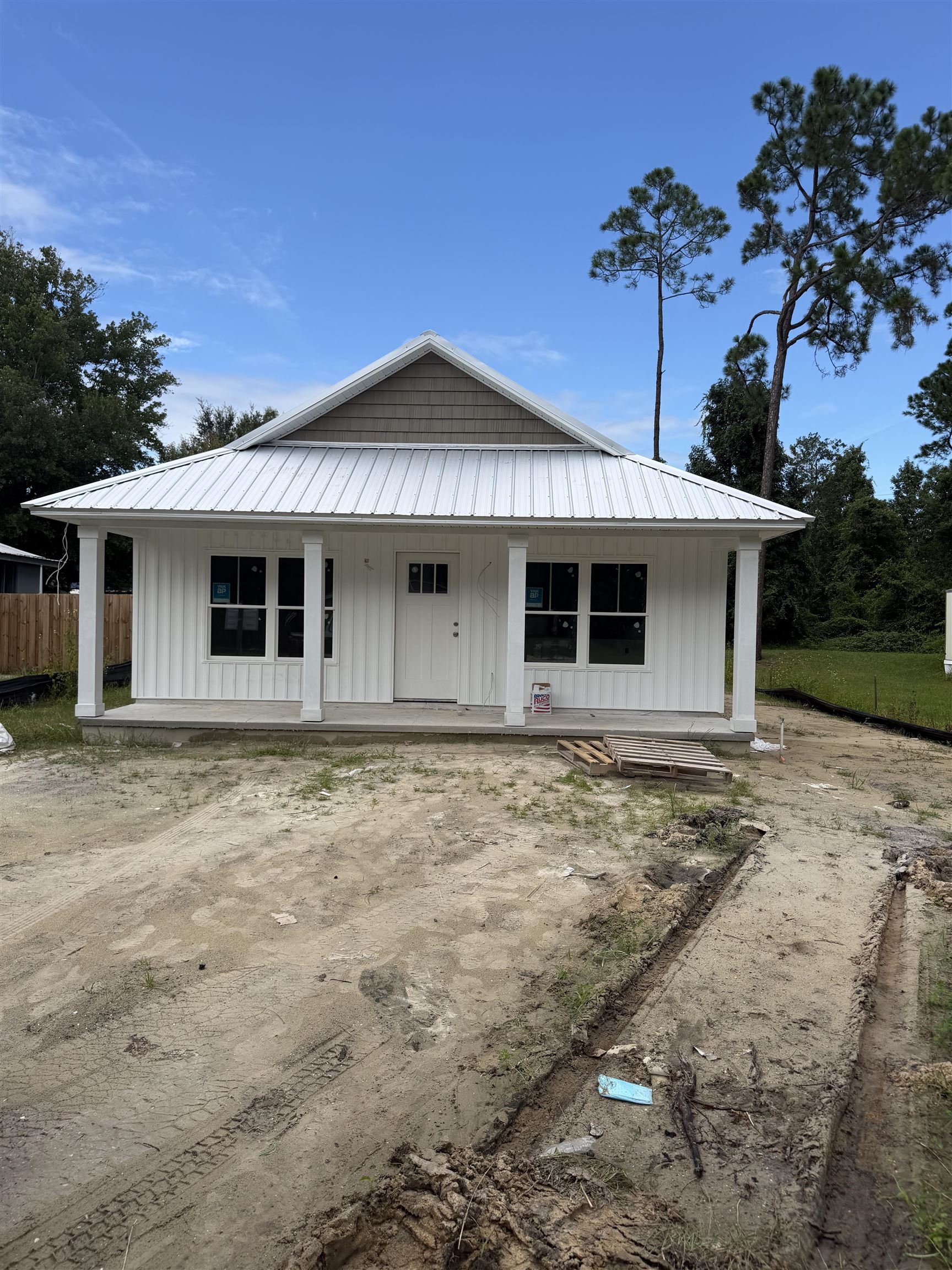 White board-and-batten siding with a corrugated metal roof Front Of Structure