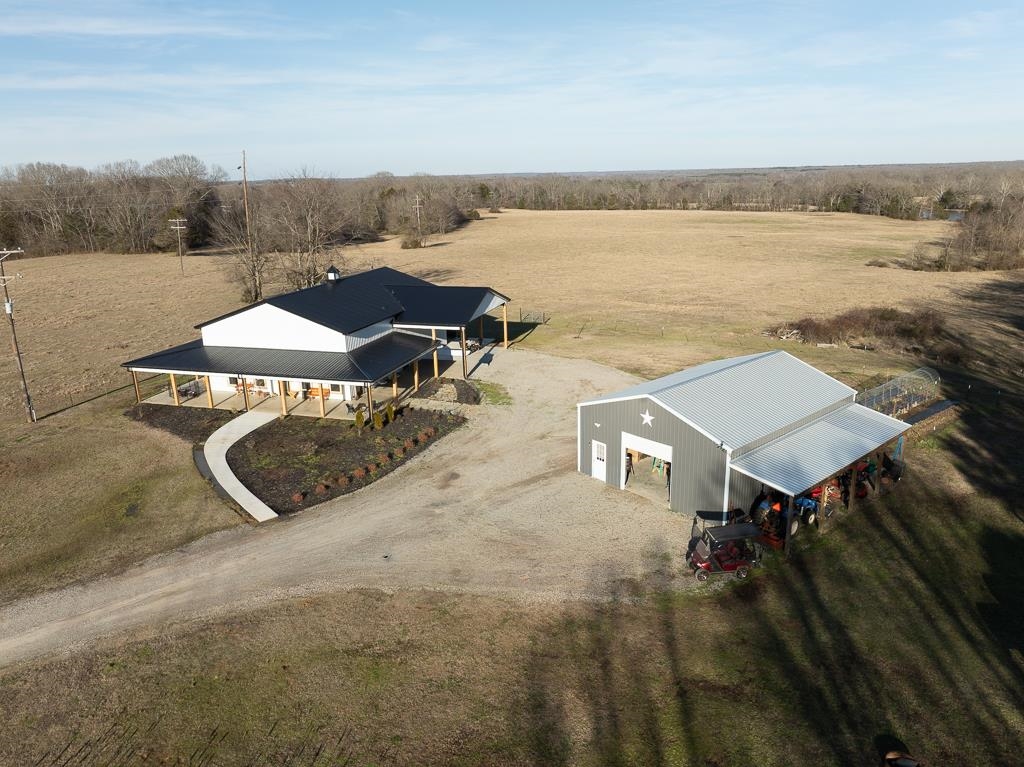 Magazine-worthy barndominium on 22.2 private acres within the Somerville city limits. Set far off the road down a long private drive, this property offers total serenity, frequent wildlife sightings, and beautiful natural surroundings. Wrap around porches invite you to relax and enjoy the views. Inside, luxury vinyl plank flooring, gas cooking, and double insulation provide both style and comfort. A lofted upstairs office adds character and flexible living space. A 30x40 shop with a full bath and (2) 10x010 roll up doors is ideal for a workshop or storage. Fish in your own pond stocked with bass, crappie, and bluegill, and enjoy the convenience of city water and sewer with the feel of a private retreat. Survey and additional documents available upon request. Agent is related to seller.