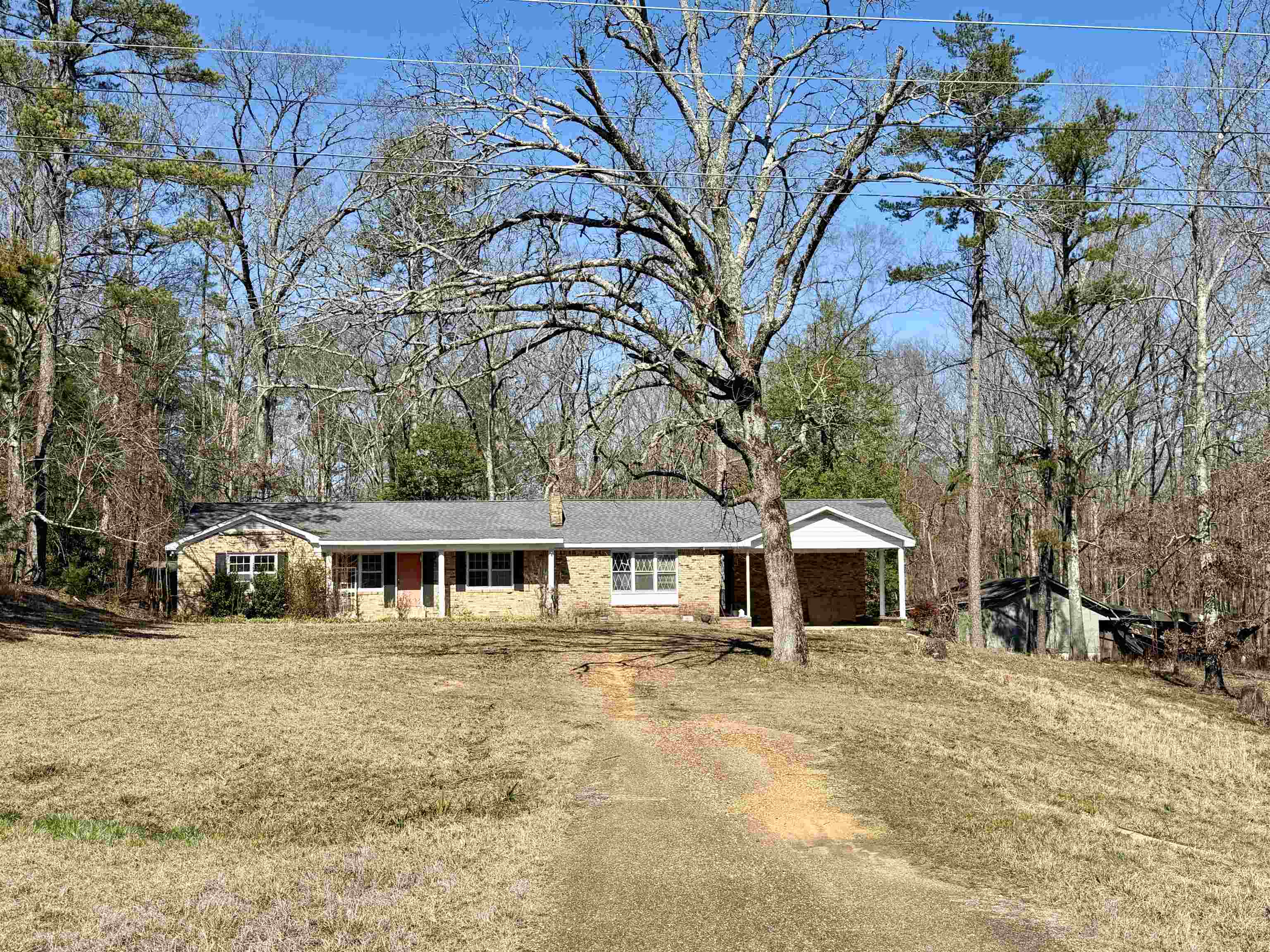Welcome to this 3 bedroom, 2 bathroom home, beautifully placed on 4 acres of land! The interior boasts a spacious living room, a cozy den, and a sunroom perfect for unwinding. The exterior features a convenient double carport for parking and a storm house for added safety and security. The home has a new HVAC unit, new plumbing under the house, and has an encapsulated crawlspace. While this charming home needs some tender loving care, its potential for renovation and renewal is vast. With a little TLC, this home can become your dream retreat!