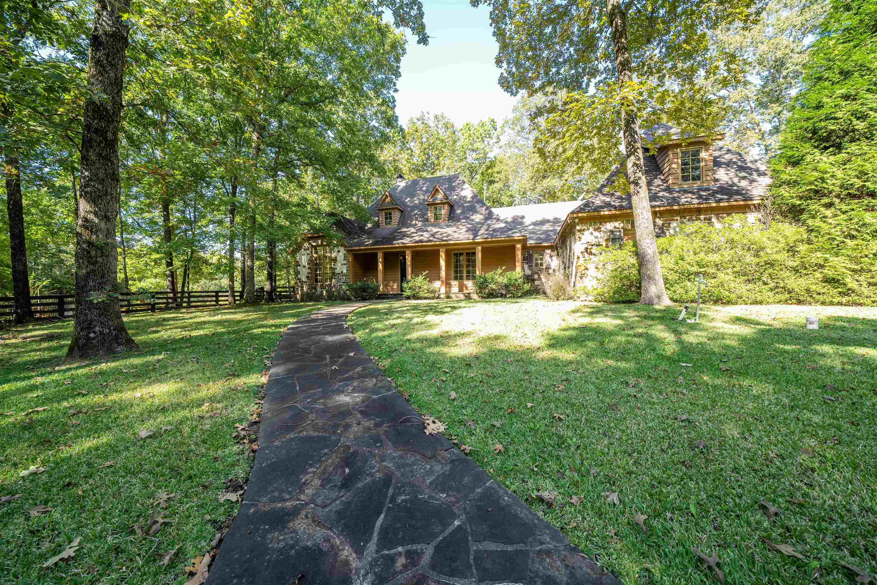 Luxury home in the country on 9+/- acres with a second multi use building garage/workshop/office/basement combo building and lots of concrete for parking areas. Home features hardwood floors throughout 1st level with tile in baths. Kitchen features center island w breakfast bar, granite tops, farmhouse sink, gas cooking, bayed breakfast room, 3 bedrooms down, 2 full baths, great room/w wood burning stone fireplace and rustic beams, large laundry room featuring a sink, granite tops and lots of cabinets, two large pantries. 3 gas HVAC units, 3 car garage, 53x10 screened back porch facing adjacent lake. Has 1 pond on this property with its own well.