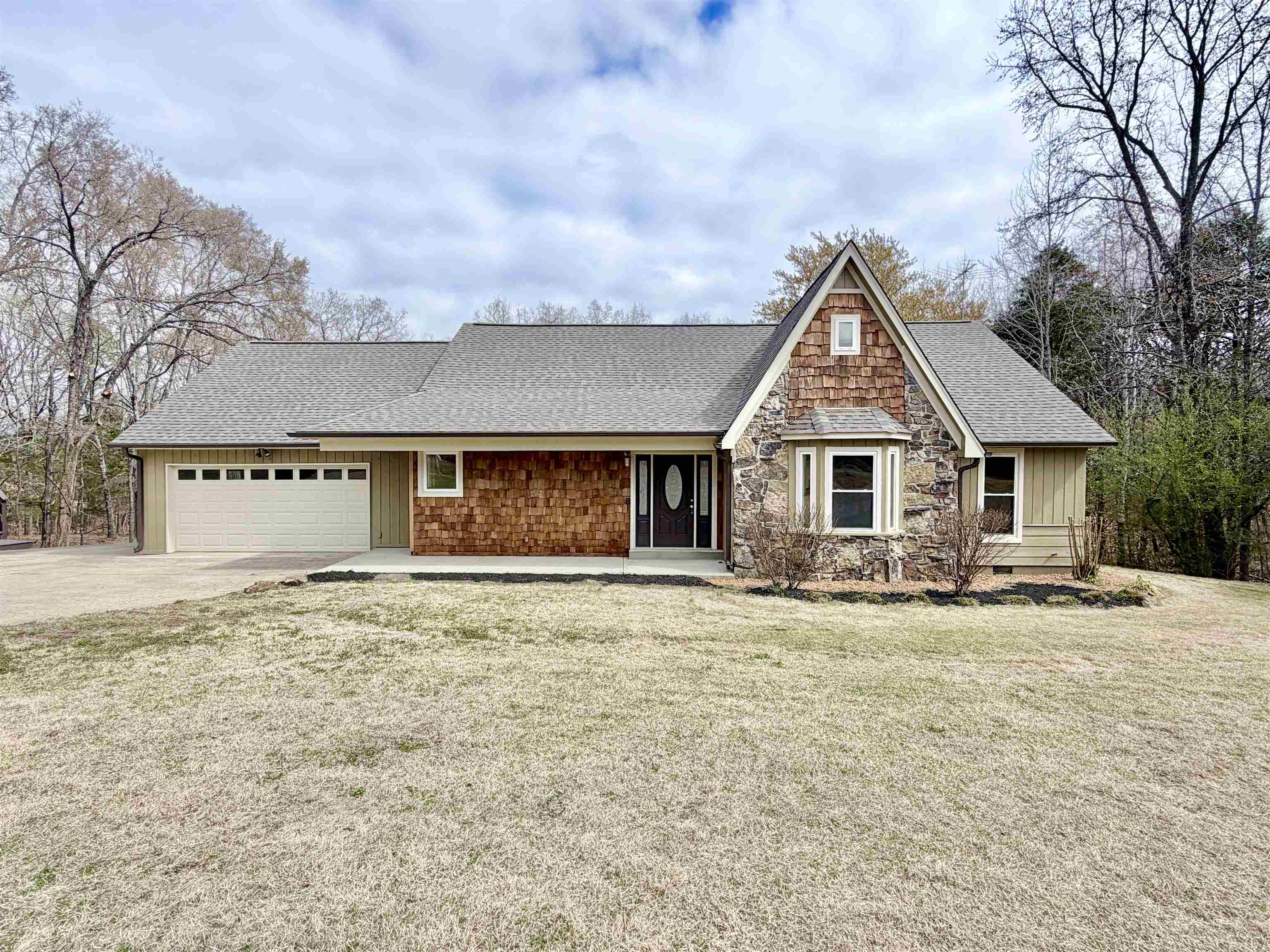 Freshly updated waterfront home on 2.57 acres with beautiful views and modern finishes throughout. The interior and exterior have been freshly painted, featuring elegant Oyster White inside. The home offers granite countertops in the kitchen, new carpet and pad in the bedrooms, and matching brushed nickel fixtures and hardware throughout. Each bedroom features its own private bathroom, providing comfort and privacy for family or guests. The home showcases vaulted ceilings with exposed beams that create an open and inviting living space. Enjoy outdoor living on the huge wraparound deck overlooking the property, perfect for relaxing or entertaining. A fire pit in the backyard adds to the outdoor charm. Car enthusiasts and hobbyists will appreciate the total of four garage spaces, including a detached garage/workshop. Additional upgrades include a brand new roof.