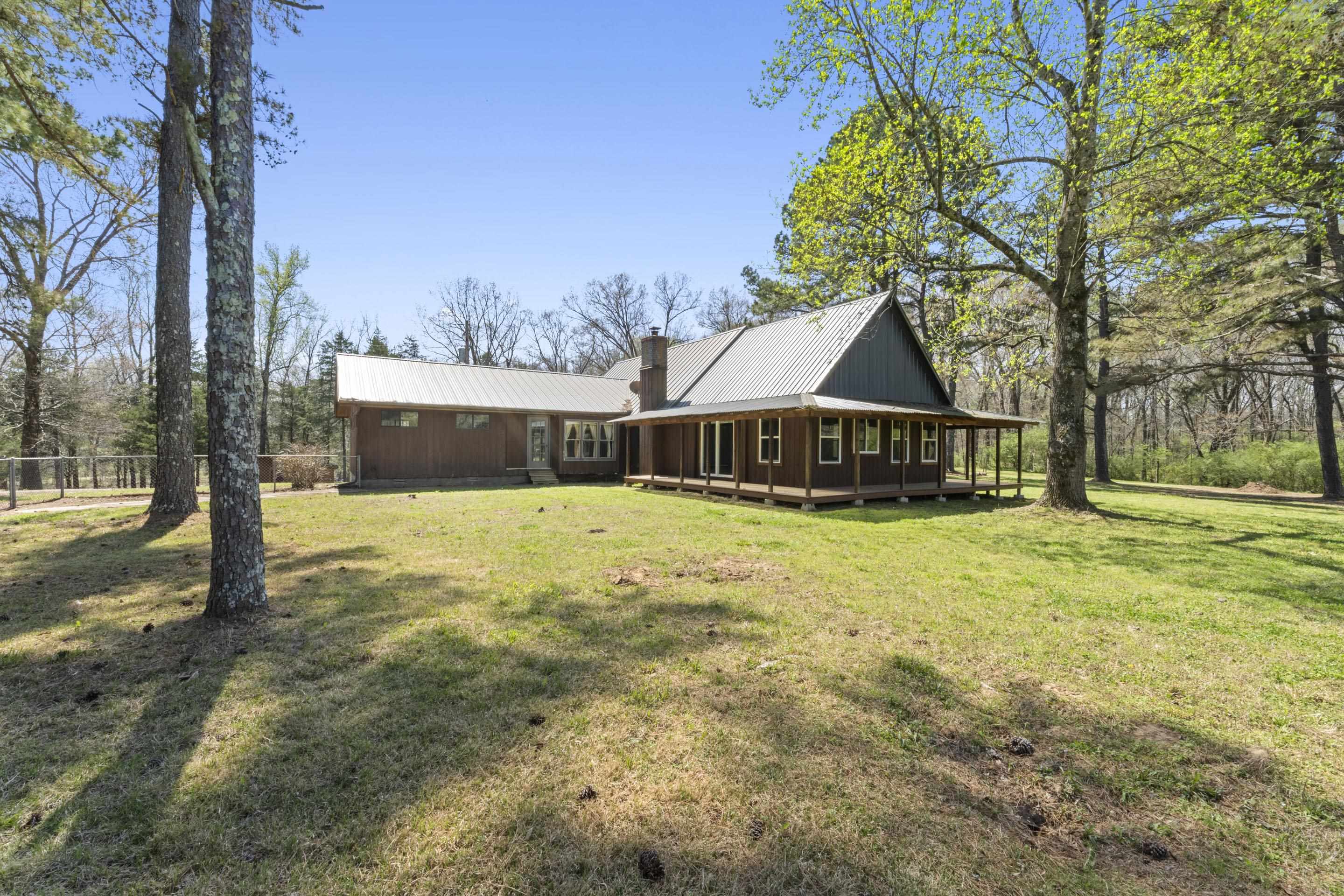 Experience the ultimate gentleman's hobby farm on 11+ acres in unincorporated Fayette County. This rustic cabin-style retreat is perfectly equipped for horses or cattle, including a powered barn with water and animal stalls. At the heart of the estate lies a serene one-acre stocked pond, complemented by a charming guest house/lodge—the perfect escape for visitors and weekenders. The main home offers a functional layout with the primary suite, second bedroom, and office on the first floor, plus a versatile loft bedroom with a half bath upstairs. A large sunroom offers endless possibilities to extend the entertainment. The property boasts a detached workshop, ATV trails, covered RV parking to house all your equipment and toys. New floors, fresh paint, and ready for you to explore. Whether tending to the land or enjoying the view, this property offers a rare blend of utility and rustic luxury. A unique opportunity for those seeking a true country lifestyle. Call now!