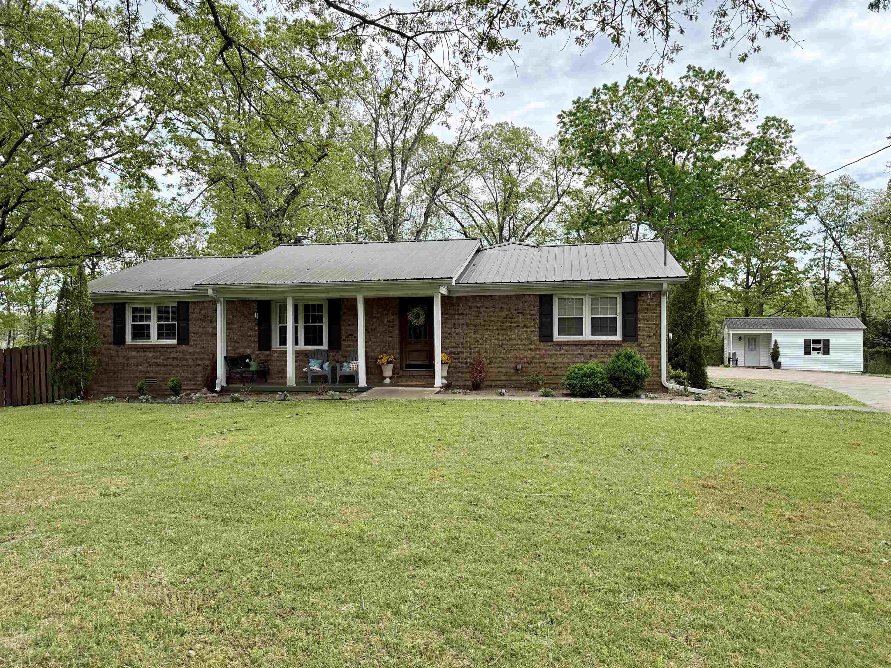 Welcome to this 3 bedroom, 2 bathroom home, beautifully designed for the ultimate living experience near town! The interior boasts sleek LVP flooring throughout, while the custom kitchen dazzles with stylish cabinets and a convenient breakfast bar, complete with stainless steel appliances. A cozy den provides additional living space, and the screened-in porch invites effortless outdoor entertaining.  The fenced-in backyard offers privacy and seclusion, while the 3-car garage and separate storage building provide ample space for vehicles, hobbies, and more. Whether you're looking for a peaceful retreat or a convenient home base, this property has it all!
