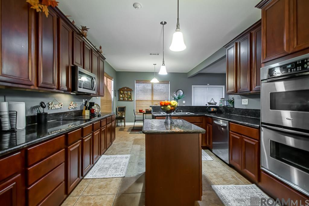 Welcome home to a sprawling, move-in-ready sanctuary tucked away on a quiet, dead-end street in Bayou View Estates - This 5 bedroom, 3.5 bath gem is the definition of effortless luxury living - Imagine your evenings unfolding here in your expansive living room, bathed in the glow of the cozy fireplace after a long day - The open floor plan flows seamlessly into a spacious, island centered kitchen, the perfect setting for everything from quiet family dinners to lively gatherings - Beyond the grand foyer, the formal living and dining rooms offer elegant spaces ready for your treasured holiday traditions - Unwind as your private Master Suite awaits, a true retreat featuring a spa-like bath with a separate shower and a blissful garden tub, complimented by dual vanities - Assumable VA Loan option - Enjoy the community clubhouse and pool - Easy access to I-10, shopping, restaurants, and the Tanger Outlet Mall just minutes away - Measurements and acreage are not warranted by the Realtor