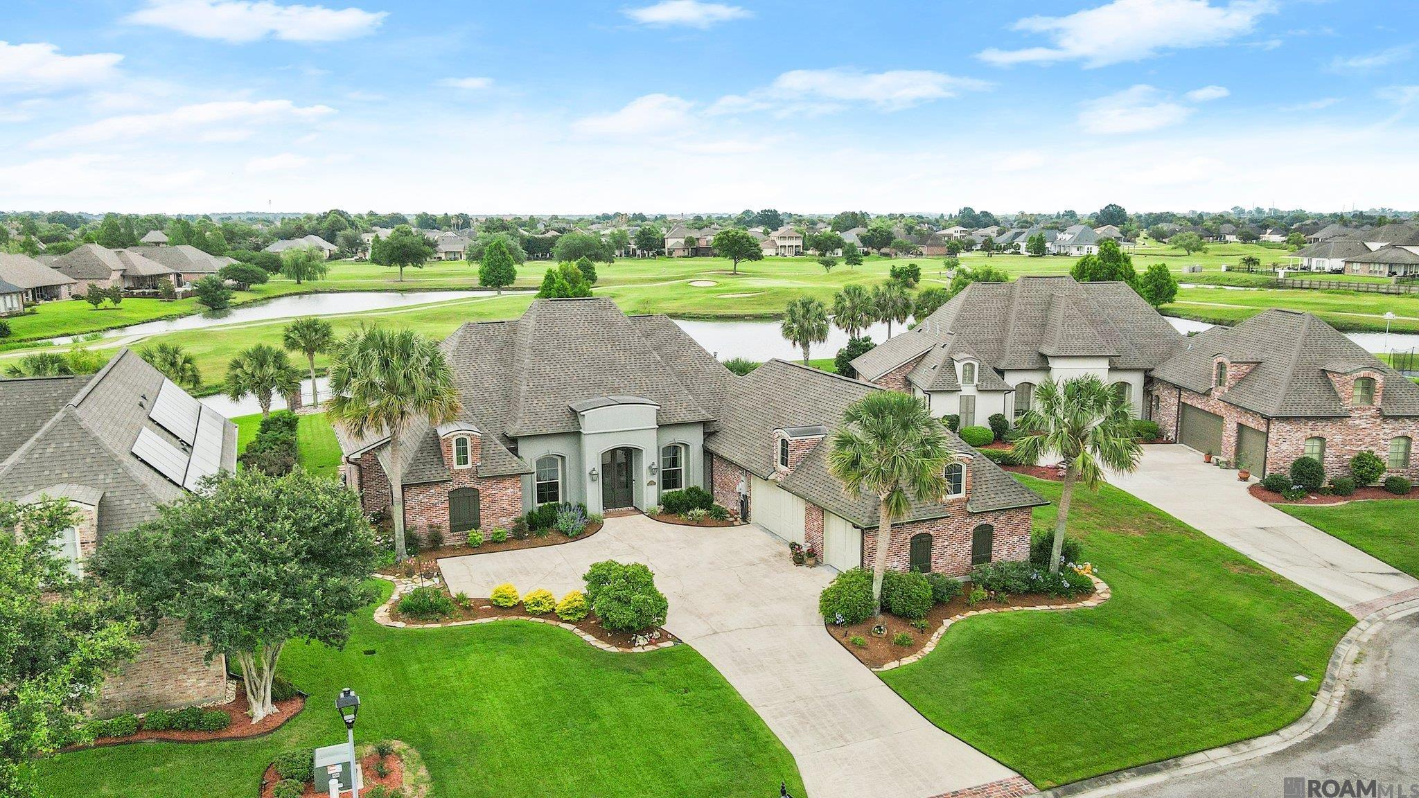One of a kind lot you don't want to miss! This outdoor oasis offers a stunning setting with all the extras you could want in Pelican Point Golf community. Gunite pool, waterfront lot w golf course views, outdoor kitchen, whole home generator, 3 car garage and so much more. This custom 4BR/3.5BA home w/office/study has been meticulously maintained w/upgrades and recent improvements eliminating maintenance worries. The open floor plan includes generously sized foyer, living, dining and kitchen with stunning views from all areas and new paint throughout. Classic heart of pine flooring is featured throughout the living areas and all bedrooms – No Carpet! Kitchen has huge island with barstool seating, stainless appliances, gas cooktop, double ovens, large walk-in pantry and generous cabin and counterspace. The master suite features bedroom with views, separate office with desk and built-in storage, and bath w/frameless glass shower, corner tub, dual vanities, large closet w/built-in dresser. The triple split bedroom plan has 2 bedrooms sharing a Jack n Jill bath and 4th bedroom off garage with private bath. Oversized laundry room w/sink and mud area w storage. Outside is an entertainers dream with generous patio space, gunite pool w/waterfall feature, outdoor kitchen, stunning landscape with palm trees and lighting, full irrigation system, fully fenced ½ acre lot with bulkhead overlooking the golf course. Replaced in last few years: new roof, new hvac units, all new windows, new stucco, new tankless water heaters, new palm trees, new computer for irrigation system, and so much more. Located at culdesac w little traffic. Features Sheet w/upgrades and improvements available. Flood Zone X, no flood insurance required. Pelican Point offers championship golf, lakes, tennis courts, pool, playground, clubhouse w/restaurant/bar, jogging trails and nightly security. Main Street shopping center at entrance has grocery store, restaurants and much more!