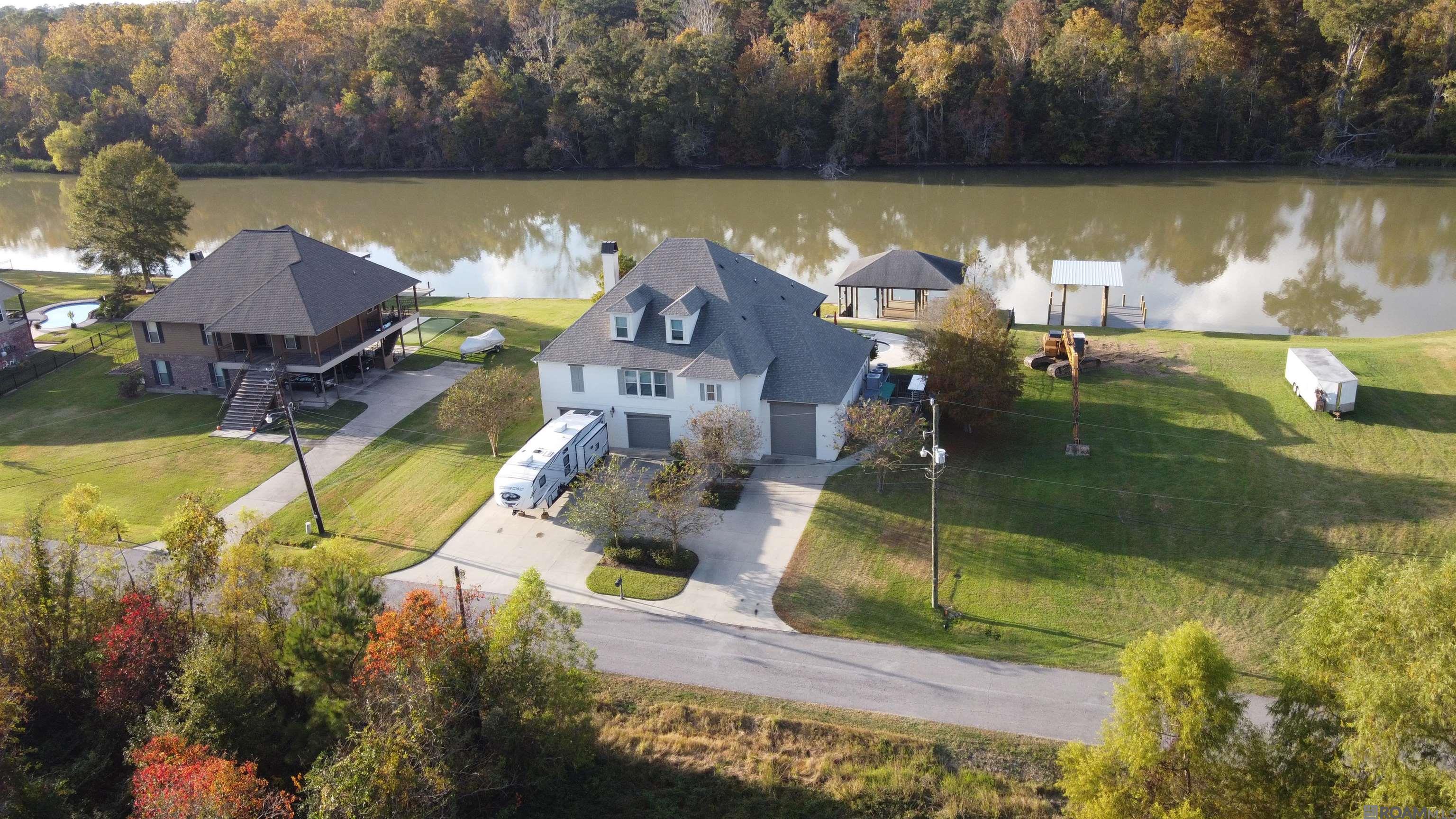 Waterfront living on the Amite River in Prairieville! Step outside directly onto your boat! This immaculate, thoughtfully designed home offers direct river frontage with the rare ability to cruise by boat to dinner at sunset or enjoy excellent fishing. A true Louisiana SPORTSMAN'S DREAM HOME with unmatched access to recreation & relaxation. Located in desirable Amite Acres, zoned for Ascension Parish Schools, this property features NO HOA dues with easy access to Baton Rouge; New Orleans is just one hour away. Built for durability, comfort & low maintenance, the home includes spray foam insulation, multiple HVAC systems, plus GENERATOR-READY setup with a 500-gallon propane tank & pre-installed services. Outdoor living shines with a HEATED GUNITE POOL & SPA, ground-level pool bath & shower, pool cabana with outdoor firepit, plus two outdoor kitchens on the upper balcony & lower covered porch. The expansive covered area beneath the home is ideal for entertaining, crawfish boils or relaxing riverside. Parking includes COVERED SPACE FOR 4 VEHICLES plus an extended concrete driveway for additional parking. The property offers 1 boat lift, 2 boat slips & an oversized river deck completed in 2018 for easy boating, fishing & sunset cruising. A vinyl retaining wall completed in 2018 adds durability, while an irrigation system supports easy landscape care. An oversized shop beneath the living area provides enclosed BOAT & RV STORAGE, extensive built-in storage & a cargo lift. Inside features southern yellow knotty pine floors, two brick fireplaces (wood-burning & gas), plus a main-level primary suite, creating comfort & functionality. The open-concept layout features a stunning kitchen with a large island, a living area with a wall of windows showcasing BEAUTIFUL RIVER VIEWS, plus neutral finishes throughout, making this home truly move-in ready. Quiet riverfront living with space, recreation & thoughtful design - schedule your private tour today!