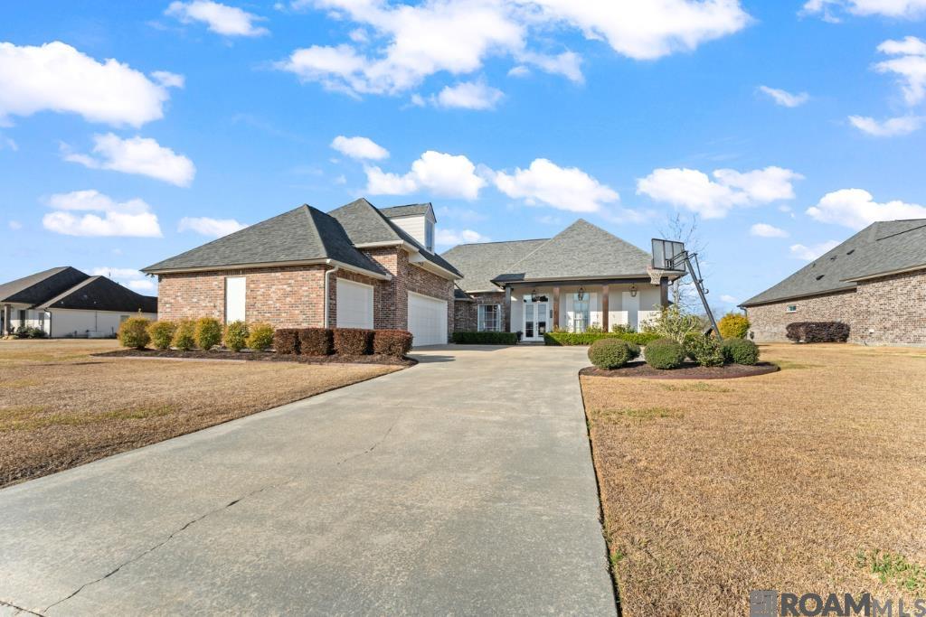 Where sunset views meet designer detail, this custom Manchac-built showpiece captures the very best of Pelican Point living. Positioned on the golf course with sweeping waterfront views, this home blends classic Acadian architecture with refined transitional design, featuring exposed beams, brick accents, custom millwork, soaring ceilings, and designer colors throughout. The chef’s kitchen offers honed granite, gas cooktop, custom cabinetry, and butler’s pantry, opening to spacious living areas. The primary suite includes tray ceilings, dual vanities, soaking tub, multi-head shower, and two walk-in closets. Triple-split floor plan with three additional bedrooms down and a large bonus room upstairs. Outdoor kitchen, electric drop-down screens, Bahama shutters, and gunite pool (7.5 yrs) overlook breathtaking golf and water sunsets. Whole-house generator (4 yrs), newer roof (5 yrs), radiant-barrier decking, and fresh paint complete this exceptional home.