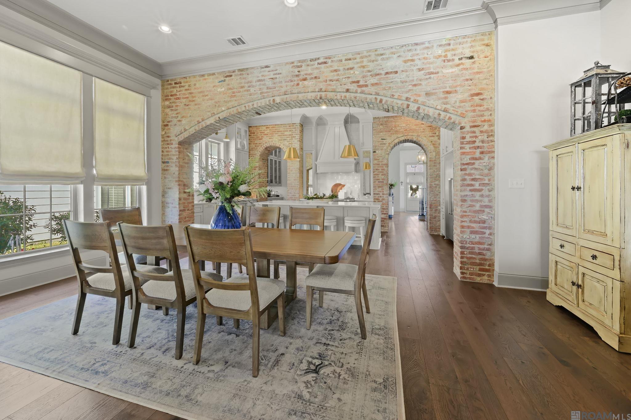 Luxury Living at Its Finest.  Built by the renowned Rabalais Homes and featured in the 2019 Parade of Homes, this stunning 4-bedroom, 4.5-bath estate with a flexible bonus space offers timeless design and exceptional craftsmanship throughout. From the moment you step inside, the old brick arches framing the kitchen create warmth and architectural charm that truly set this home apart. The chef’s kitchen is a showstopper, complete with high-end appliances, designer lighting, quartz countertops throughout, and a spacious butler’s pantry perfect for entertaining. A built-in Thermador side-by-side refrigerator with a center wine cellar elevates the space even further. The primary suite is a private retreat with serene lake views right from your bedroom. The spa-inspired bath features a massive walk-in shower, dual vanities, and a separate seated vanity area designed for hair and makeup. And the closet?  It’s HUGE and thoughtfully designed for maximum storage and organization. Step outside to your own resort-style oasis. The covered outdoor kitchen includes a gas stove and built in grill. The patio area showcases a fireplace, retractable mechanical screens on all sides, and a convenient half bath…all overlooking the lake. There’s plenty of room to add a pool while still enjoying generous yard space. Additional features include a full-home Generac generator for peace of mind. This home perfectly blends luxury, comfort, and functionality all set against breathtaking waterfront views. All custom window treatments and (10) TVs to remain. Schedule your personal tour today to become the lucky owner of this stunning beauty!