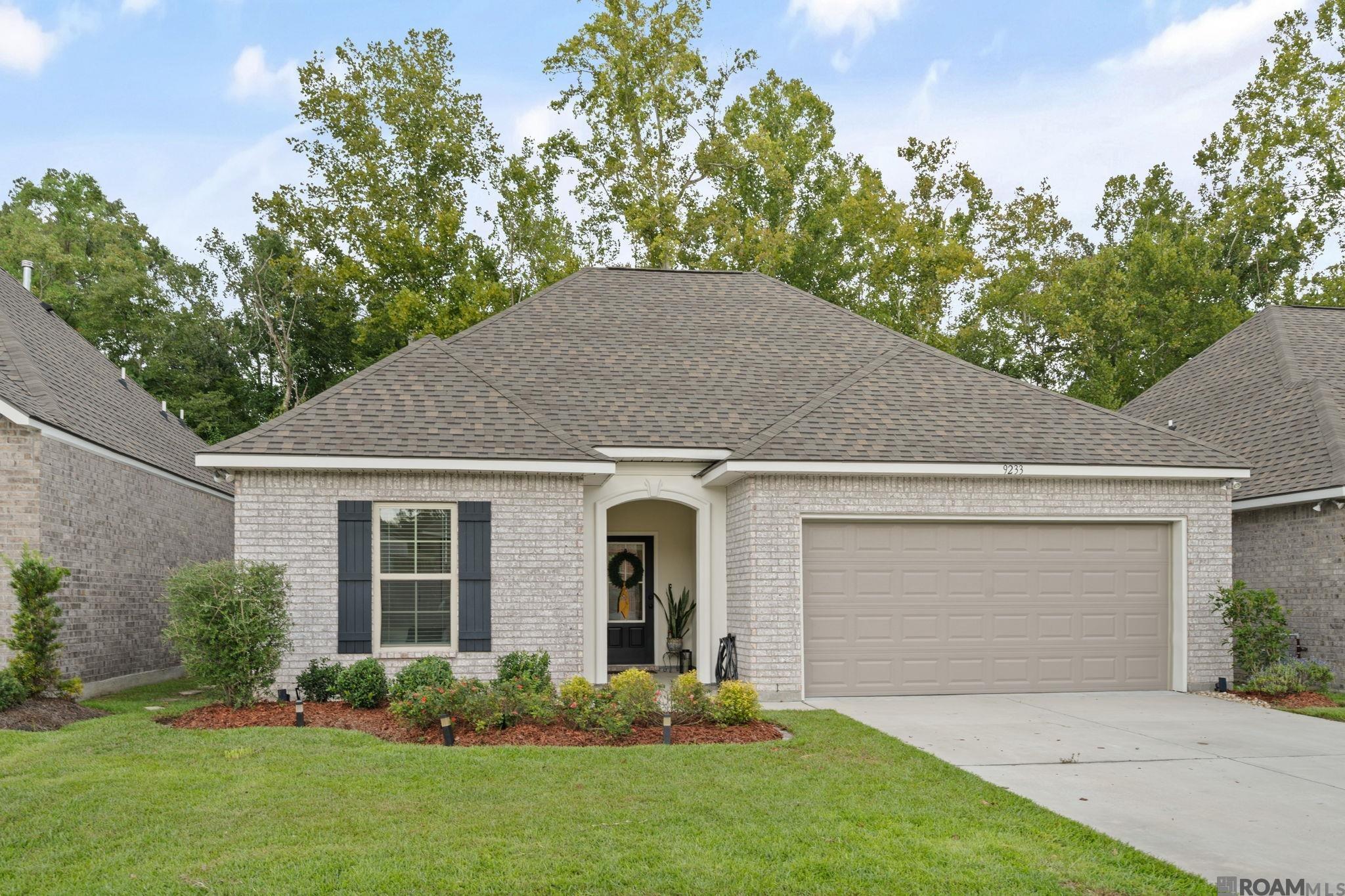 This beautifully maintained 3-bedroom, 2-bath home was built in 2023 and offers a spacious open floor plan with neutral colors and thoughtful features throughout. The kitchen is designed for both everyday living and entertaining, featuring quartz countertops, a large center island, 5-burner gas range, stainless steel appliances, under-cabinet lighting, and a walk-in pantry. Luxury wood-look ceramic tile flooring flows throughout the main living areas, complemented by recessed lighting. The spacious primary suite features a private bath with quartz countertops, double vanity, separate tiled shower, garden soaking tub, and a large walk-in closet. Additional highlights include a convenient mud room, low-E tilt-in windows, tankless gas water heater, and post-tension slab. The home also includes a 2-car garage and plenty of storage throughout. The washer, dryer, and refrigerator are negotiable, and the desk in the third bedroom will remain if the buyer would like it. With its newer construction, desirable location, stylish finishes, and move-in-ready condition, this home is an excellent opportunity! Located just minutes from LSU, Perkins Rowe, The Mall of Louisiana, BREC parks, restaurants, shopping, and entertainment, this home offers both convenience and comfort.
