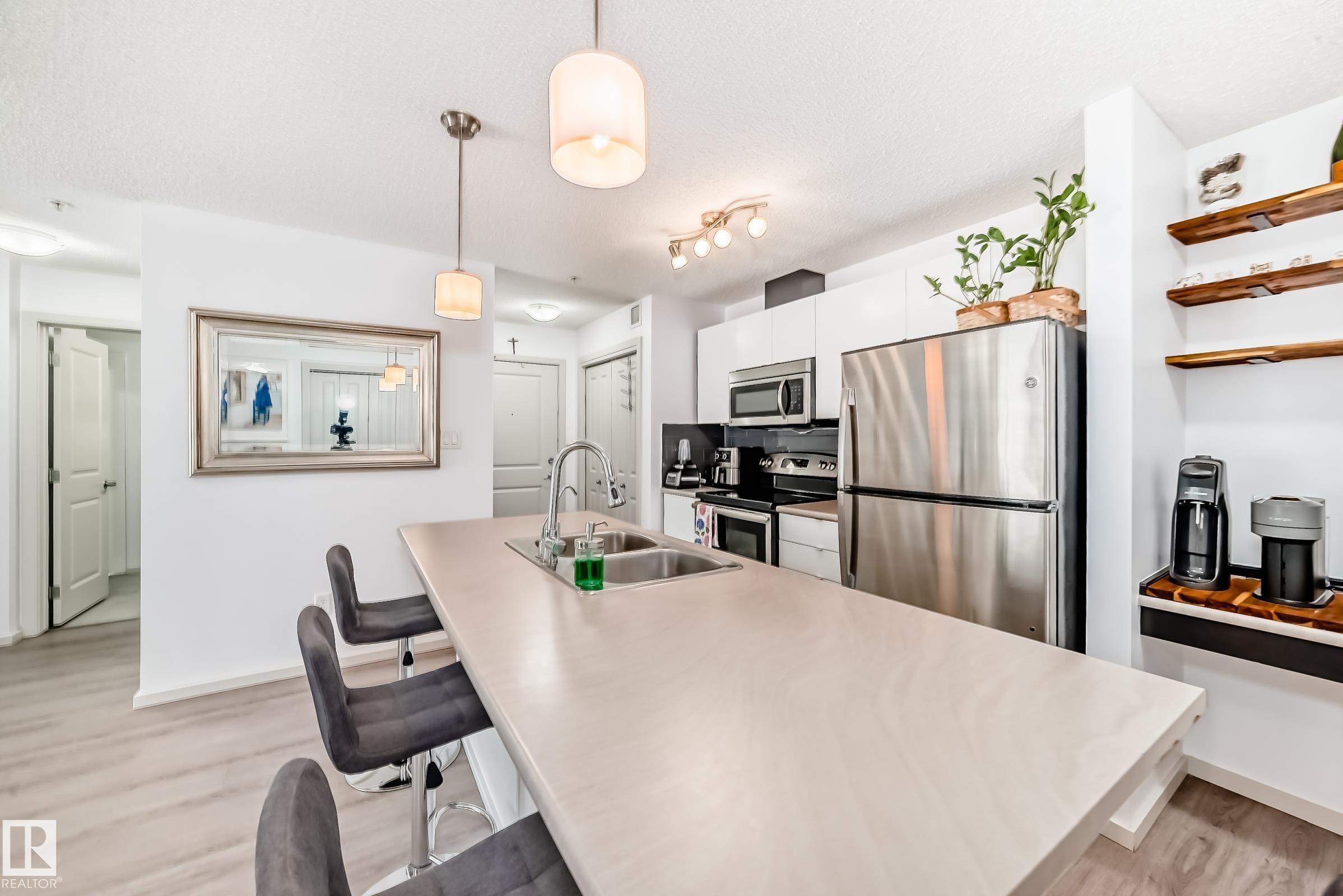 Gorgeous CORNER  unit Nestled in the vibrant community of Windermere, on MAIN FLOOR with 1 TITLED PARKING STALL. Total of 830sqf . Enjoy one of the best locations in the complex with this absolutely immaculate ready to move in condo unit. Spacious & open floor plan kitchen, huge island with space for breakfast bar and a big pantry for storage and Large living room . 2 Bedrooms on opposite sides of the unit. Huge master bedroom features a huge walk-through closet and a 4-piece ensuite. Second bedroom and another full bathroom will satisfy all NEEDS! The unit features a private balcony as well as convenient in-suite laundry. Just steps from your door, you?ll find a variety of nearby amenities, plus quick access to the scenic North Saskatchewan River valley and Terwillegar Dog Park, ideal for walking and outdoor activities. Commuting is a breeze with Anthony Henday Drive.