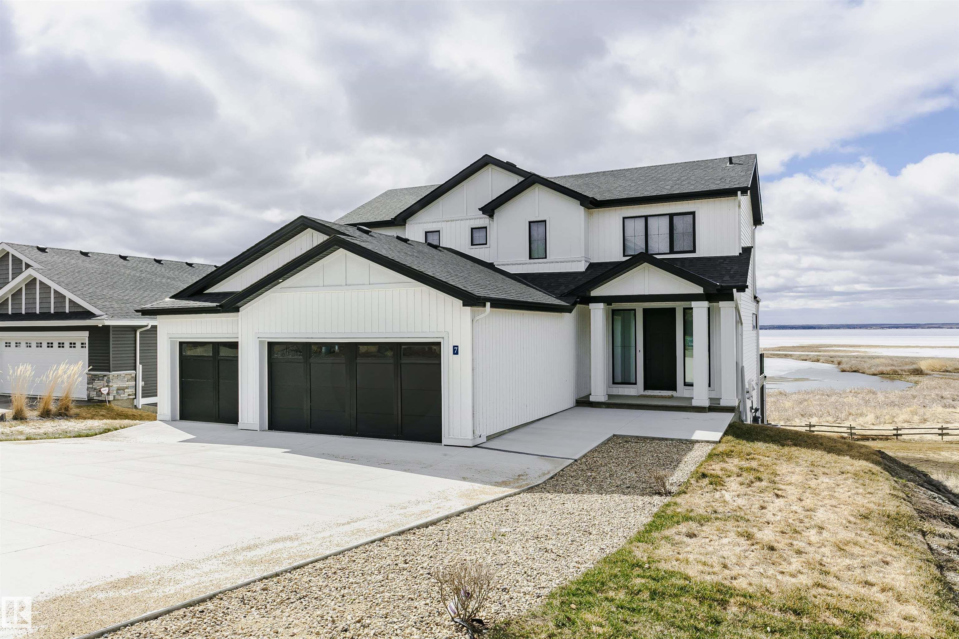 Amazing custom built WATERFRONT WALKOUT 2 story now available. Soaring vaulted clearstory story ceilings on the main floor great room featuring an island kitchen, large lakeside dining, floor to ceiling f/p feature, glass wall to den and large patio sliders out to the south facing main deck. The main floor is also host to a large front entry, garage mudroom (both with hockey benches), a 2 piece bath, laundry and walkthrough pantry. Rise up the open web stair case with custom rail to the upper floor which is home to 2 PRIMARY bedrooms with ensuites, walk-in closets and each its own private lakeside deck. They are on opposite ends of the home connected by a bridge. Downstairs you will find a huge family/rec room with wet bar, 2 more bedrooms (one with built-in bunks), 2 bathrooms and doors out to the screened-in patio. You will also enjoy the triple attached garage, gas bbq hook-up, central a/c, community pool along with fitness centre, clubhouse, beachfront park, marina and R/V storage option.