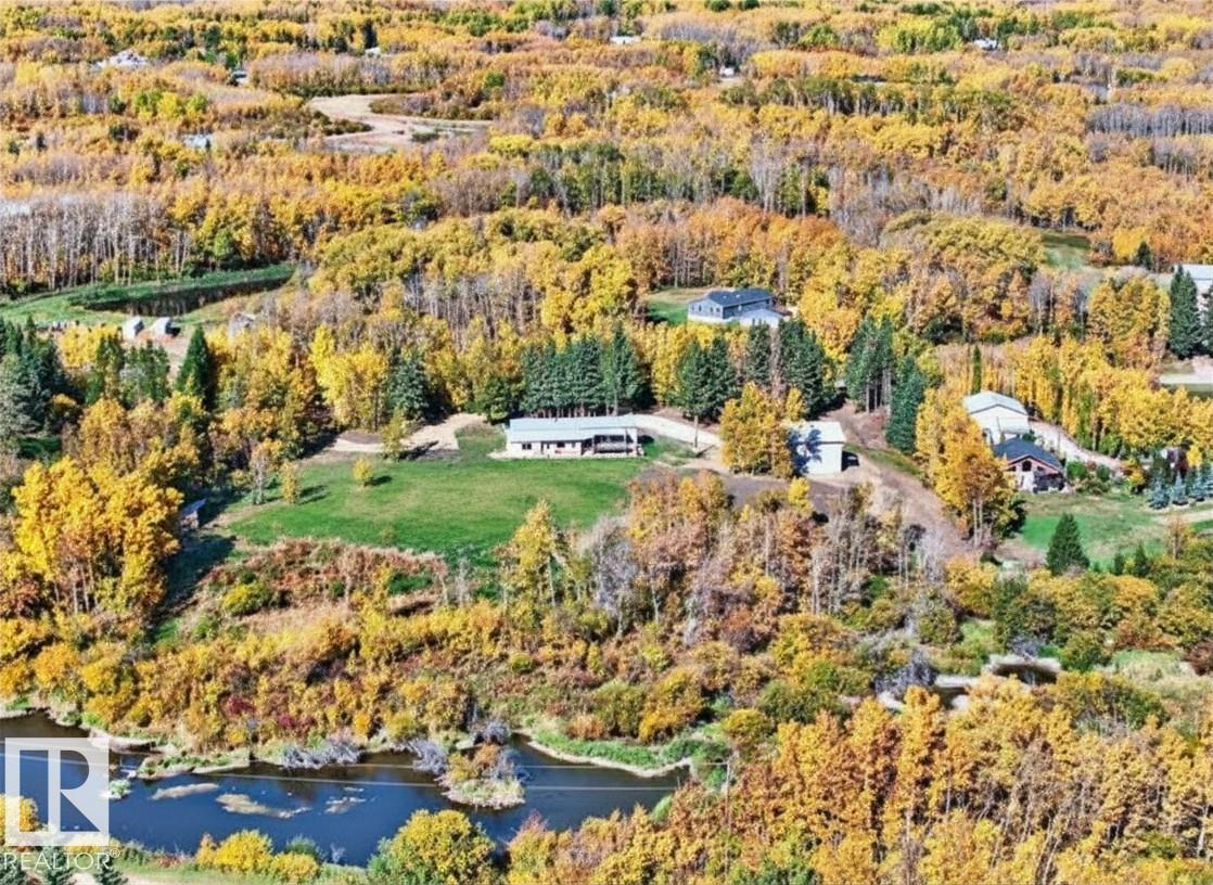 Nestled on 3.06 private acres, this peaceful country retreat backs onto a tranquil creek and protected environmental reserve, offering privacy, nature and stunning views. Bright, modern and extensively upgraded, this 1,548 sq ft home, built in 2010, showcases new vinyl plank flooring & baseboards, fresh paint, updated lighting throughout and cozy wood burning stove. The open-concept great room flows effortlessly between living and dining, anchored by a stylish chef?s kitchen with quartz countertops, abundant cabinetry, a large island, and stainless steel appliances. The primary bedroom offers a 2-pc ensuite and private deck access, while two additional bedrooms and full 4-pc bath complete the layout. With a drilled well and septic tank & field, the property also features a potential "walkout" building site - ideal for your future home. The ULTIMATE PIT STOP is the BRAND-NEW 30' x 40' shop with 16' ceilings, two 14' industrial doors, and concrete slab reinforced with pilings...an ABSOLUTE MECHANICS DREAM!