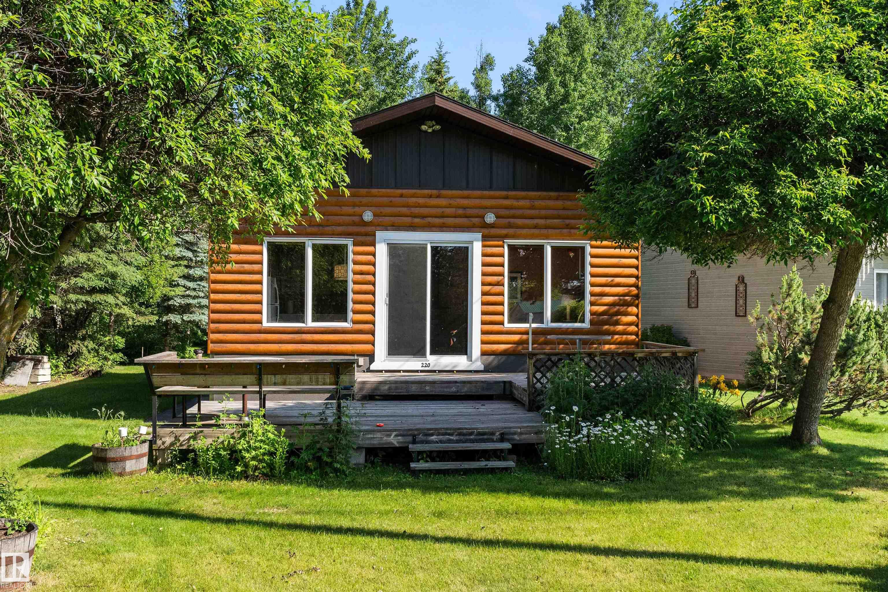 Lake Living with Flexibility Built In Lake Life, All Year Long?on a rare treed double lot in Ross Haven. This 3-bedroom bungalow offers lake views, shared dock access, and walkability to the shoreline via green reserves and a scenic lakeside trail. Start your day by the water, spend afternoons boating or swimming, and unwind on your private deck surrounded by mature trees. Inside, the home offers warm character, woodstove comfort, and a layout for relaxed living?including one bedroom kids will race to claim. The yard is built for hosting, with space for RVs, tents, and extended family stays. A detached oversized double garage adds excellent storage and flexibility. A functional water system is supported by a full holding tank and option to connect to the community grey water system?reducing servicing demands. For those considering full-time living, there is a clear path to further upgrades. A rare opportunity to enjoy lake life now, with the space, access, and flexibility to grow into more.