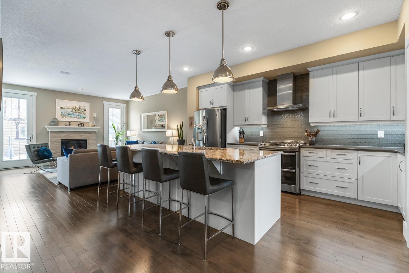 GORGEOUS IN GRIESBACH! Gourmet Kitchen is anchored by a 10' GRANITE ISLAND & features GAS STOVE, GLASS TILE BACKSPLASH & upgraded cabinetry. The Dining Room seats 10+ guests, the perfect backdrop for memorable gatherings.  Custom designed Den has garden doors leading to the WEST FACING BACKYARD. Solid hardwood flooring sets an impressive tone on this level. Loft has VAULTED CEILINGS, Juliet balcony & full bath?ideal for a media, music or games room. Finished Basement enhances functionality, while the OVERSIZED, INSULATED DOUBLE GARAGE w/ EV CHARGER adds everyday convenience. Lovely landscaped yards. Quick commute to Downtown by transit or 20 mins. by car.  15 Mins. drive to CFB /  Edmonton Garrison. Walkable community w/ many amenities - groceries, restaurants, services, daycares & schools. Plenty of parks, ponds & trails to enjoy in this friendly neighbourhood.  With 4 bdrms, 2 dens & 5 baths, this IMMACULATE, 3,700+ sq ft home offers versatility for professionals, families & multi-generational living.