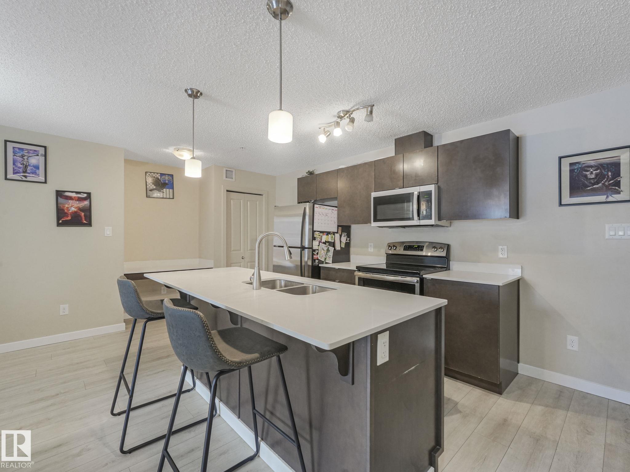 Welcome to Elements at Albany! This beautifully maintained 2 bdrm, 2 bth main floor unit, with only 1 neighbor, offers 816 sq ft of functional, open-concept living with in suite laundry & underground HEATED parking. Thoughtfully updated with newer high end laminate flooring, quartz countertops, & stainless steel appliances, the kitchen features ample cabinetry plus a convenient built-in desk area & bonus pantry. Ideal layout with bdrms on opposite sides for added privacy, both finished with durable vinyl plank flooring. The spacious primary bdrm includes a walk-thru closet & 4-pce ensuite, while the 2nd bdrm is perfectly positioned next to another full 4-pce bth. Enjoy your own private, sectioned balcony space. Located minutes to shopping, dining, transit, & all major amenities, with quick access to Anthony Henday for an easy commute in any direction. CURRENT TENTANT PAYS $1845 ***Bedroom photos are virtually altered to appear vacant***