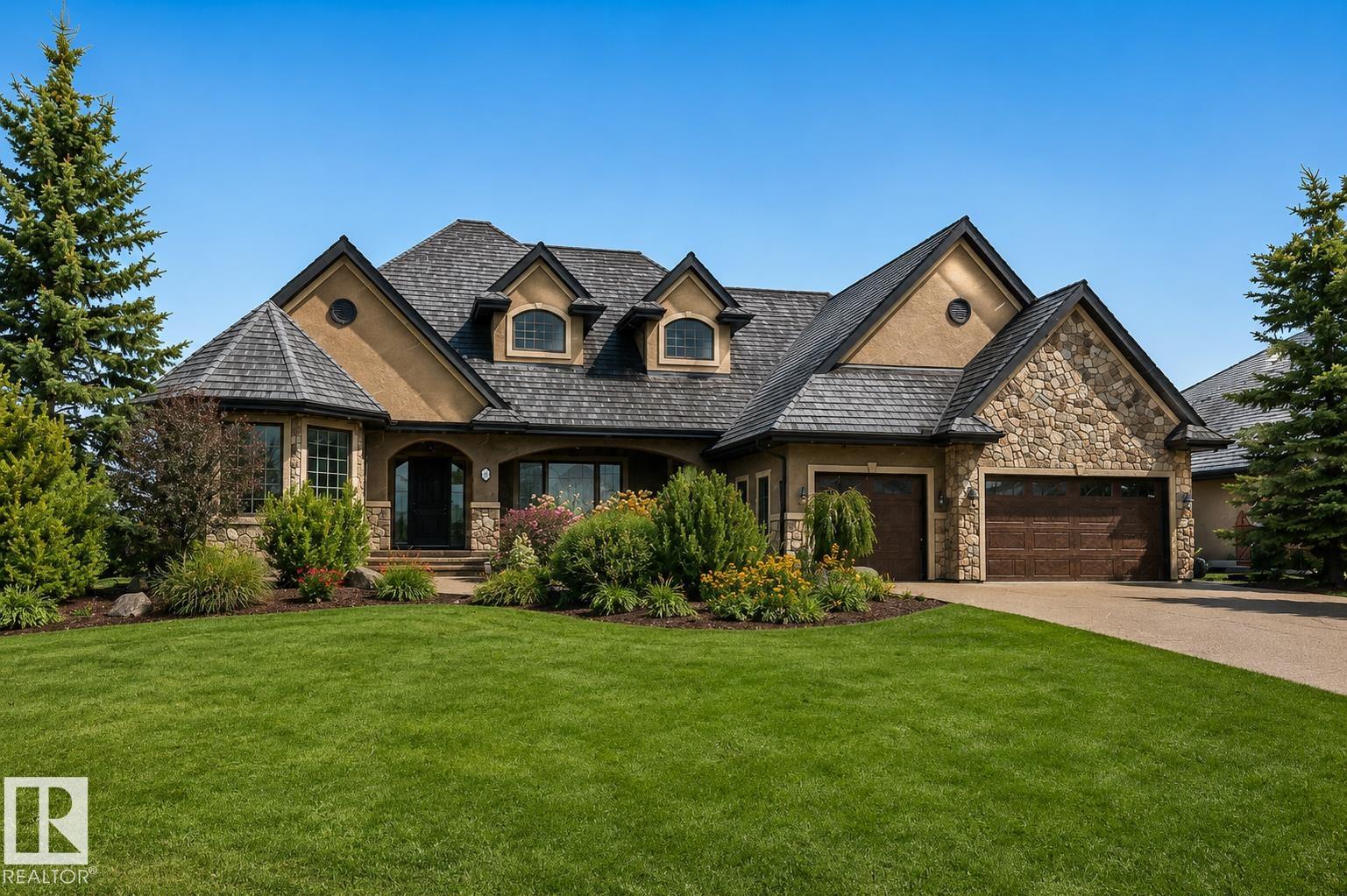 Welcome to this exceptional 2,300 sq ft walk-out bungalow by Audie Benson Estate Homes, ideally nestled in the prestigious community of Riverstone Pointe. Showcasing breathtaking views, it offers the ultimate blend of luxury, tranquility, and acreage-style living?just minutes to St. Albert and the Henday. Built to the highest standards of quality and craftsmanship, every detail has been thoughtfully curated. The main floor features a stunning primary retreat with a spa-inspired 5-piece ensuite and expansive walk-in closet, along with a private den. The open-concept living space is rich in natural light and anchored by a beautifully appointed, chef-inspired kitchen designed for both elevated entertaining and everyday living. The fully finished walk-out lower level offers 3 spacious bedrooms and an impressive family rm/games area & wet bar creating the perfect setting for hosting family and guests. A heated quad garage completes this extraordinary home?where timeless design meets an exceptional lifestyle.