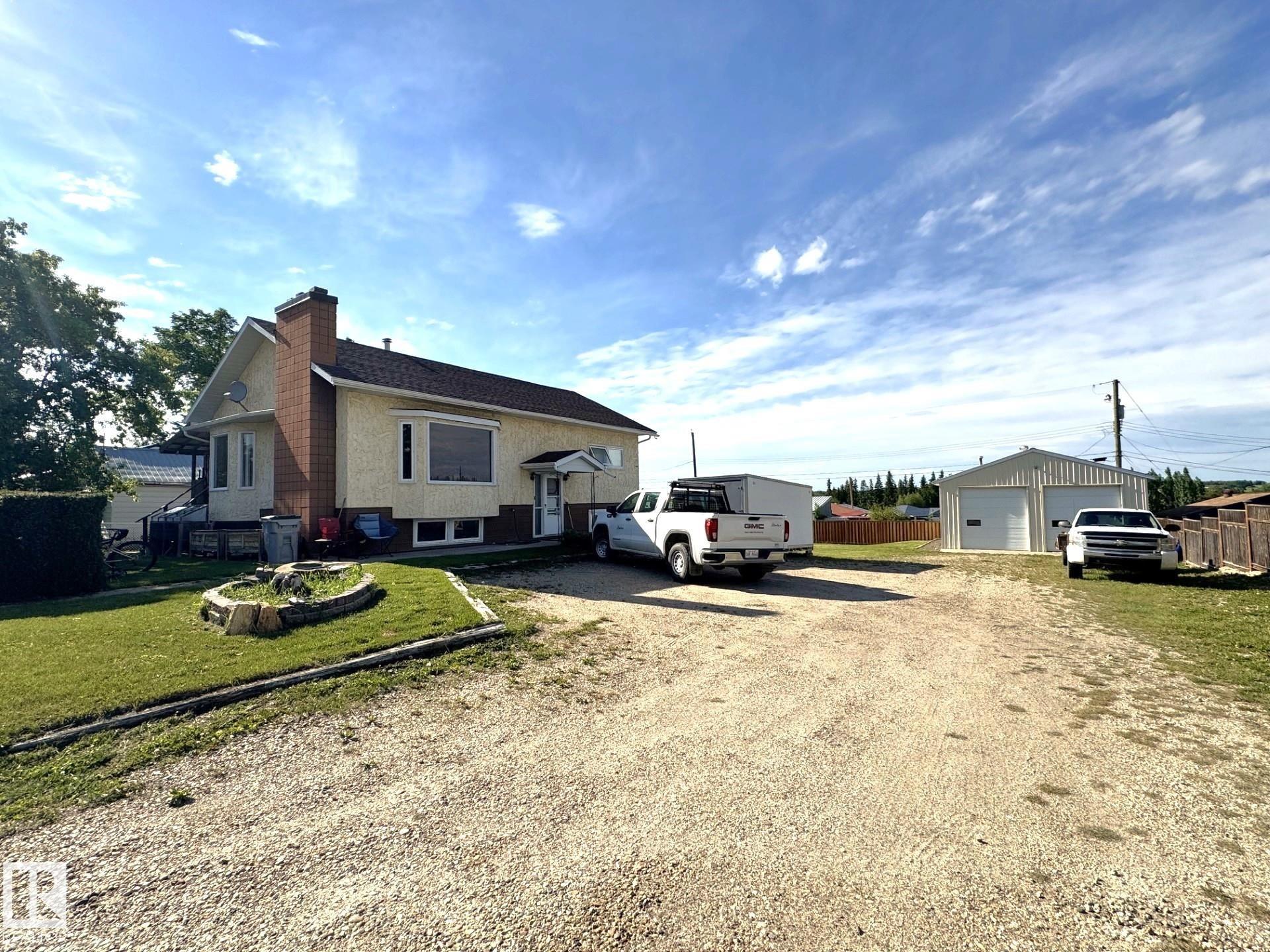 This Great Property Offers a Combination of Family Living, Premium Workshop Space & Outdoor Enjoyment. Situated on a Spacious Double Lot, This Well Maintained 3 Bedroom, 2 Bath Bilevel Home is Designed For Family Comfort. The Main Floor Features Rich Laminate Flooring, an Attractive Kitchen With Generous Cabinetry, a Bright Dining Room With a Bay Window & Garden Doors Leading to a Large Covered Deck That Has Dual Access From The Home & 2 Stairways to The Landscaped Backyard. The Welcoming Living Room With Textured Ceilings is Centered Around a Beautiful Fieldstone Wood Burning Fireplace, Making it a Perfect Gathering Place. The Fully Finished Walkout Basement Offers a Spacious Recreation Room With a 2nd Wood Burning Fireplace & Ample Storage. There is a Beautiful Partially Fenced Yard With Hedges, Cedar Trees, a Fire Pit & RV Parking. The Large Shop Has 12 ft Ceilings, 220 Wiring, a Cement Floor, 2 Mezzanines & is Heated. Located 1 Hour From Edmonton & Close to The School, Shopping & Pembina Park.