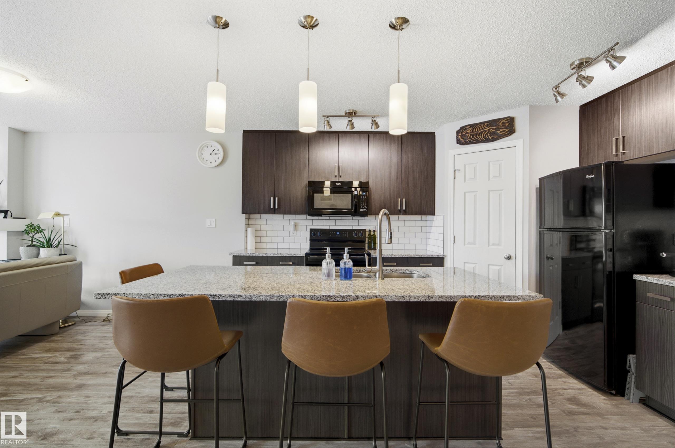 Immaculate, like new home located in the beautiful community of Paisley, just steps from walking trails and a tranquil pond. Offering 1,737 sq ft above grade, this home features 3 generous sized bedrooms including a spacious primary retreat with double French doors, a large walk-in closet, and a 4-piece ensuite. The open-concept layout showcases luxury vinyl plank flooring, newer paint throughout, a large island kitchen with granite countertops, ceramic backsplash, corner pantry, and a new stove (2025). Enjoy the warmth of the electric fireplace and the flexibility of a large bonus room. Additional highlights include upstairs laundry with emergency drain, excellent storage, 74-gallon electric HWT, high-efficiency furnace, new sump pump, and SE-facing backyard. The professionally installed, fully fenced yard features newer pressure-treated fencing, plum and cherry trees, and a weeping birch.Back alley access, an oversized attached single garage that fits a truck, custom baked enamel coated garage door.
