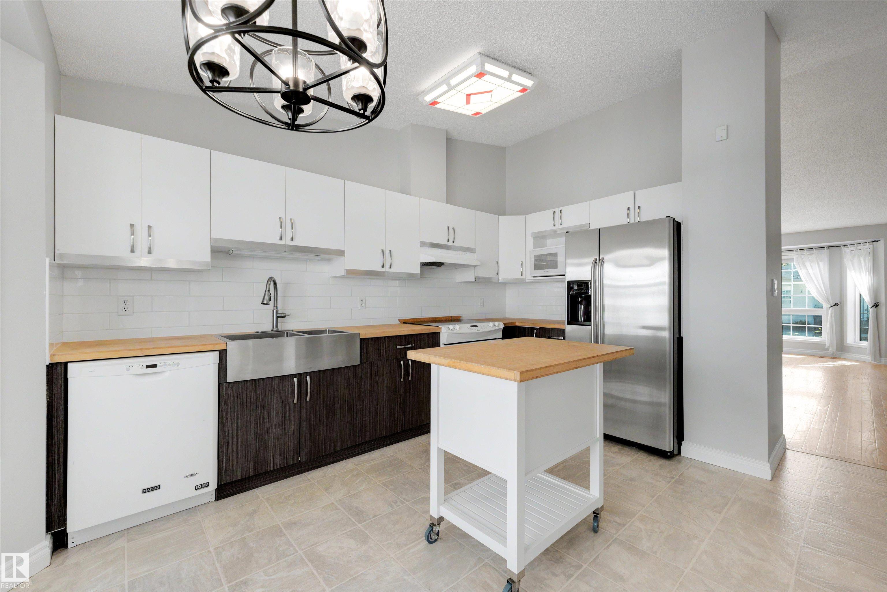 OVER 2,000 SQ FT OF FINISHED LIVING SPACE + SECOND KITCHEN + 2 PARKING STALLS! If you want the convenience of condo living without giving up the space of a house, this fully finished bungalow-style townhome is a rare find. The bright main floor features vaulted ceilings, fresh paint, a generous kitchen and dining area, comfortable living room, 2 bedrooms and a full bathroom. Downstairs adds a large family room, office/den, second kitchen, full bathroom, laundry and excellent storage, creating incredible flexibility for extended family, hobbies, guests or working from home. Enjoy central A/C, an enclosed deck with gas hookup and 2 parking stalls conveniently located directly outside. With plenty of room to spread out and no need to sacrifice single-level everyday living, this is an excellent option for downsizers or buyers seeking flexible space. Minutes from Grey Nuns Hospital, LRT, shopping, restaurants, transit and everyday amenities.