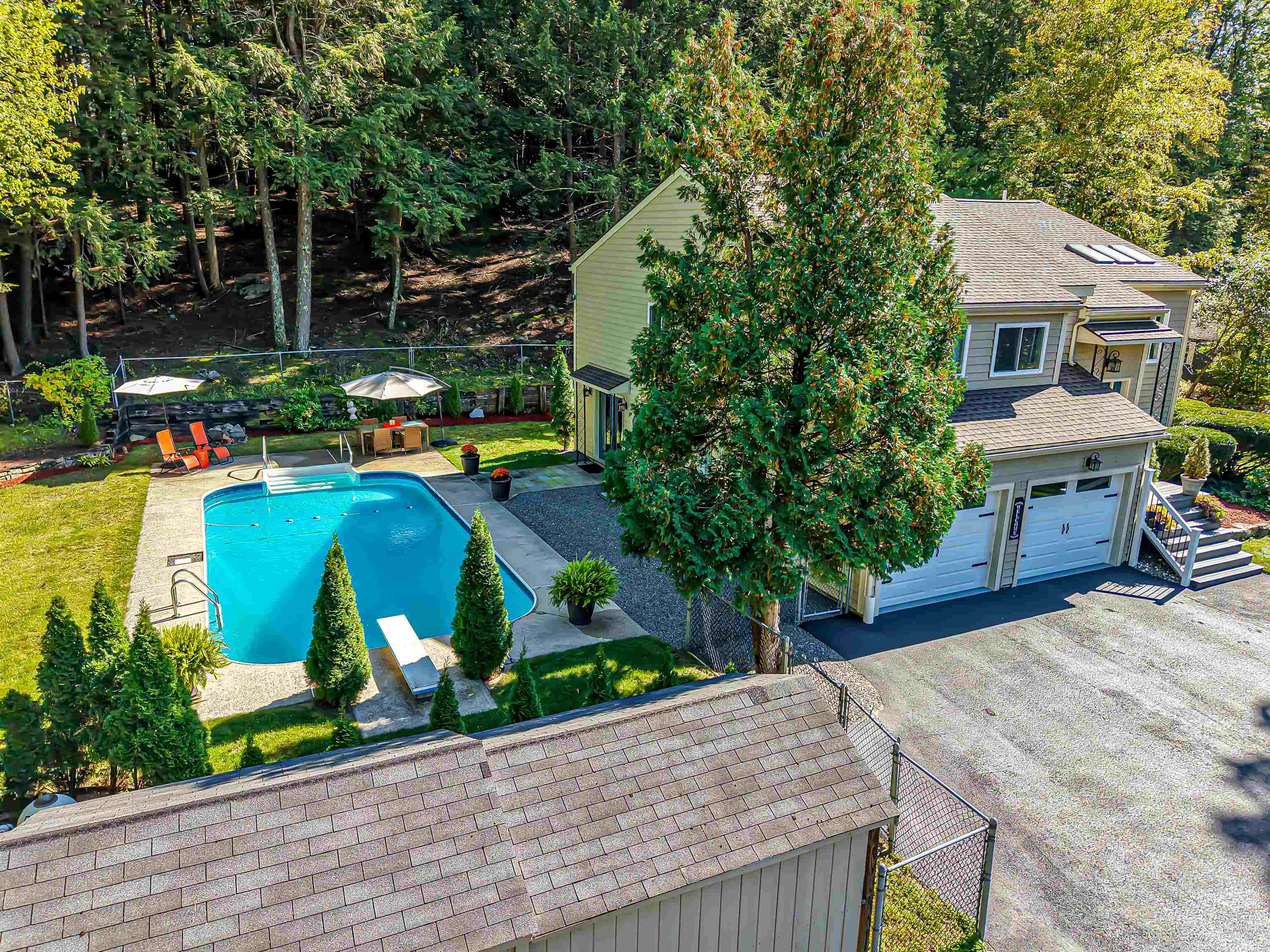 Rare find! Stunning Contemporary residence in a sought-after, quiet neighborhood features a first floor fully renovated, permitted legal in-law/ADU. The main home impresses with soaring beamed cathedral ceilings, skylights, and a dramatic two-story wood burning fireplace that anchors the elegant living space. A true centerpiece, the custom gourmet kitchen features an expansive 11-foot waterfall granite island with seating for eight, beautiful granite counters, striking industrial-style lighting, newer stainless steel appliances, a five-burner gas range, split oven with pop-up vent, in-island drawer microwave and under-cabinet lighting. Three bedrooms complete the main home with 2 newly remodeled bathrooms, including a spa-inspired primary suite with a walk-in glass shower and an elegant chandelier. Additional highlights include heated tiled floors, rich hardwood flooring throughout, central A/C, and a two-car garage. The in-law apartment is ideal for multi-generational living or income potential. Private entrance showcases a custom kitchen, stainless steel appliances and waterfall-edge granite counters. Additional highlights include LVP flooring, cozy wood stove, French doors, recessed lighting, heated tile bathroom flooring, a spacious bedroom with double closets, and direct double-door access to the pool area. Exceptional outdoor living awaits with upper and lower rear decks, a beautiful fenced-in 16x36 in-ground pool with a cabana, spacious patio areas, a wood-burning fire pit, stunning landscaping, and multiple outbuildings for storage or hobbies—creating the perfect private staycation retreat. Recent upgrades include a new roof & driveway, cordless robotic pool vac & safety cover (2024), new A/C & hot water heater (2022). The fully fenced side yard is ideal for pets,  7-zone irrigation system. Homes offering this level of design, versatility, and outdoor enjoyment rarely become available. Showings start at the Open House Saturday, March 14, 10AM – Noon!