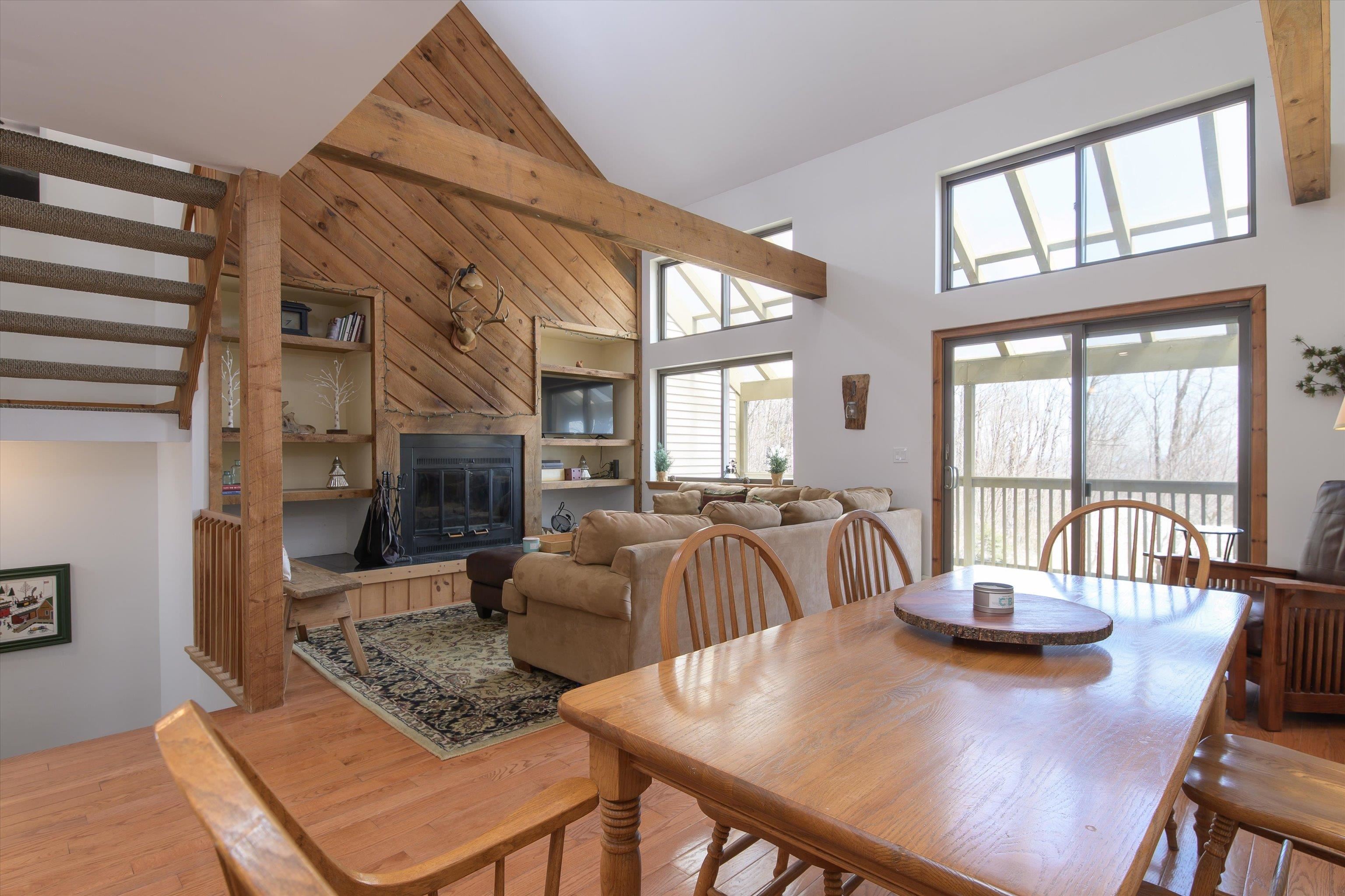Open floor plan with wood floors centered by a fireplace