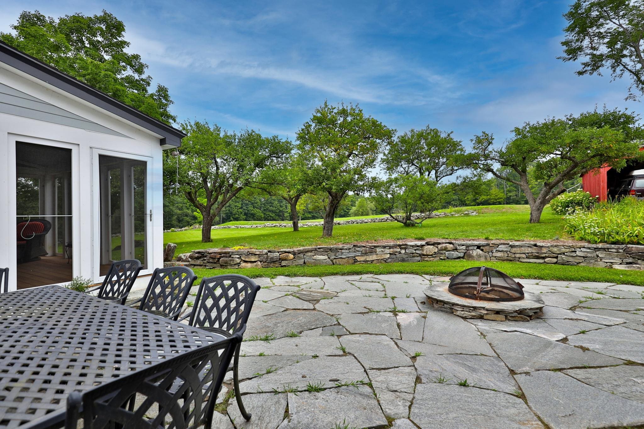 Back patio with fire pit and apple trees 25194084