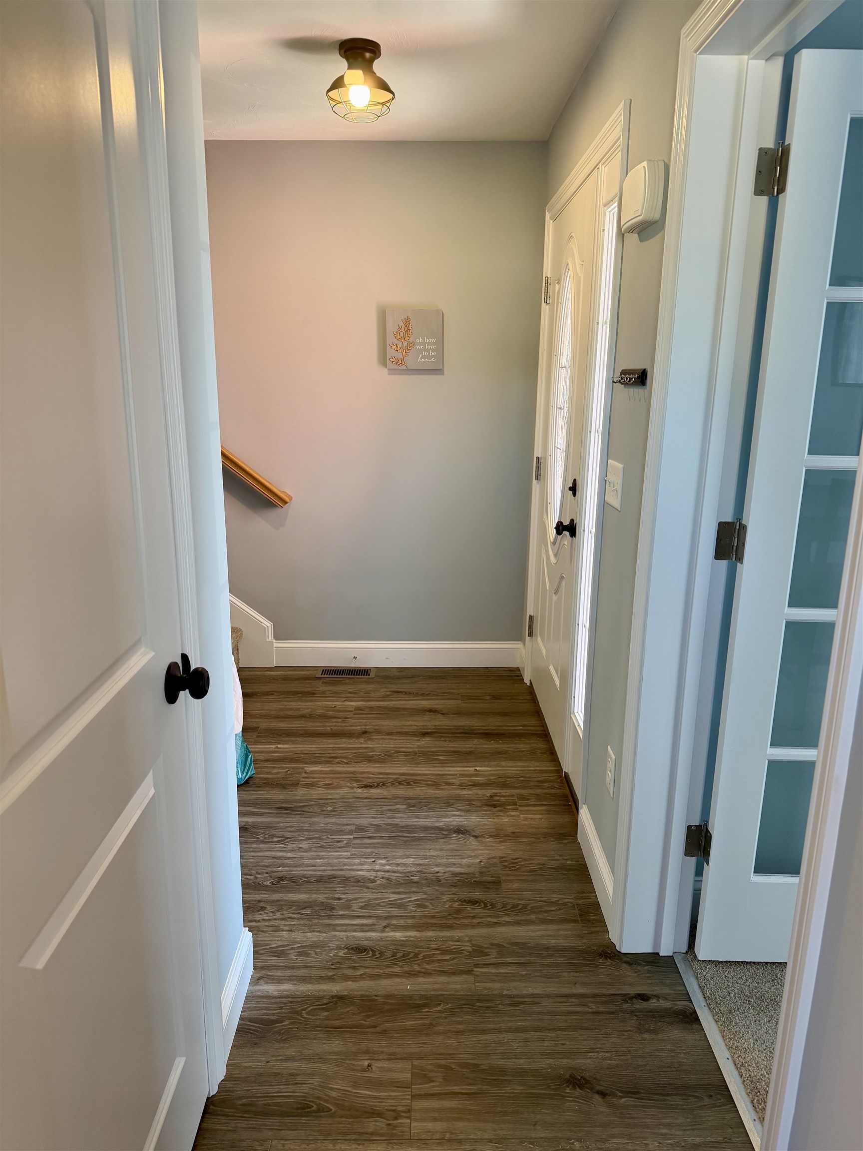 Looking from 1/2 bath to entry and stairwell.