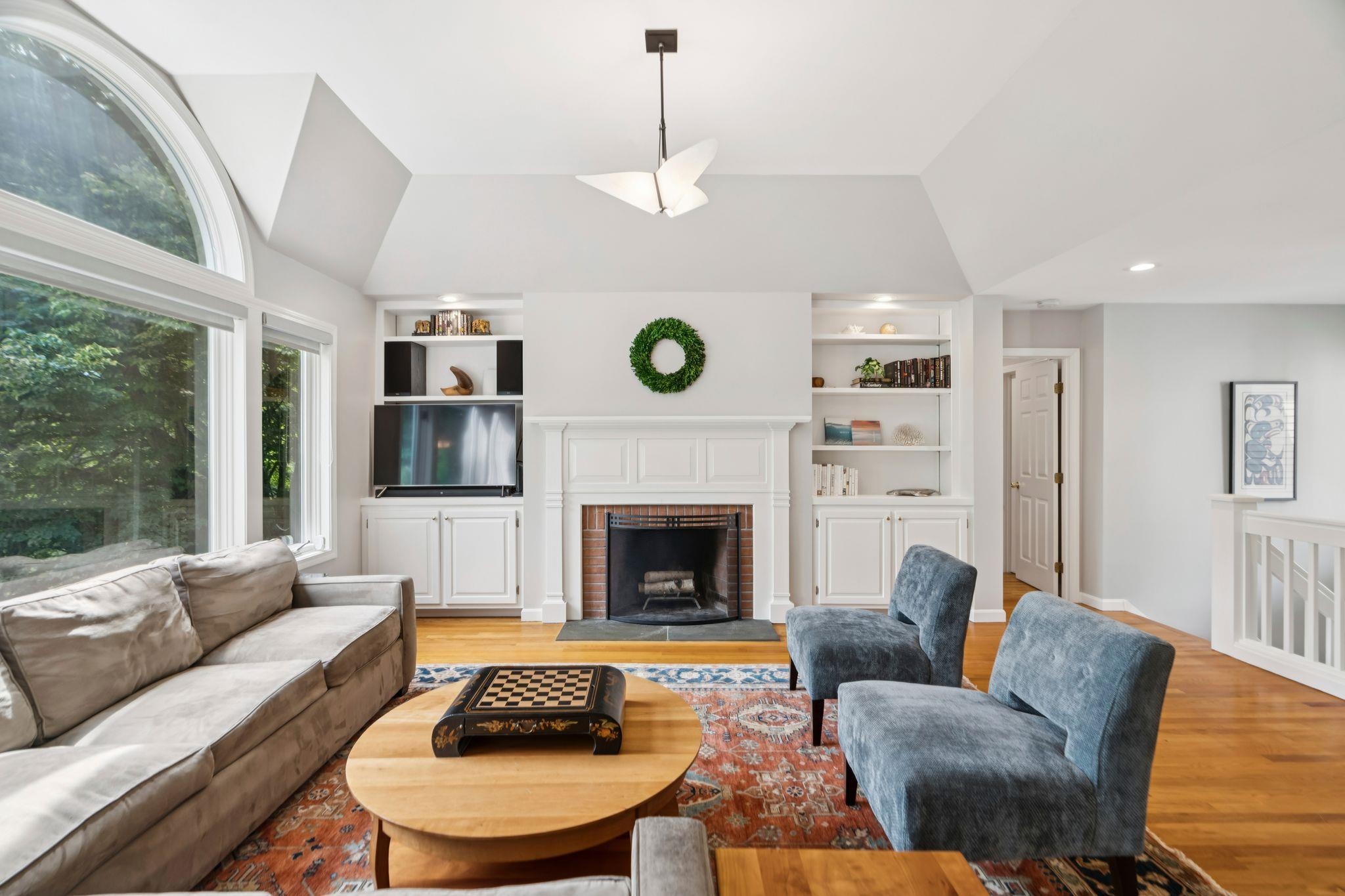 Living room facing fireplace and primary suite entry 25623874