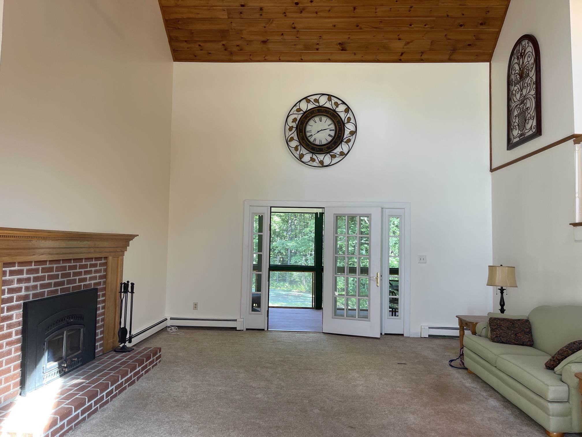 A SLIDING GLASS DOOR IN THE FAR END OF THE ROOM LEADS TO A SCREEN PORCH.