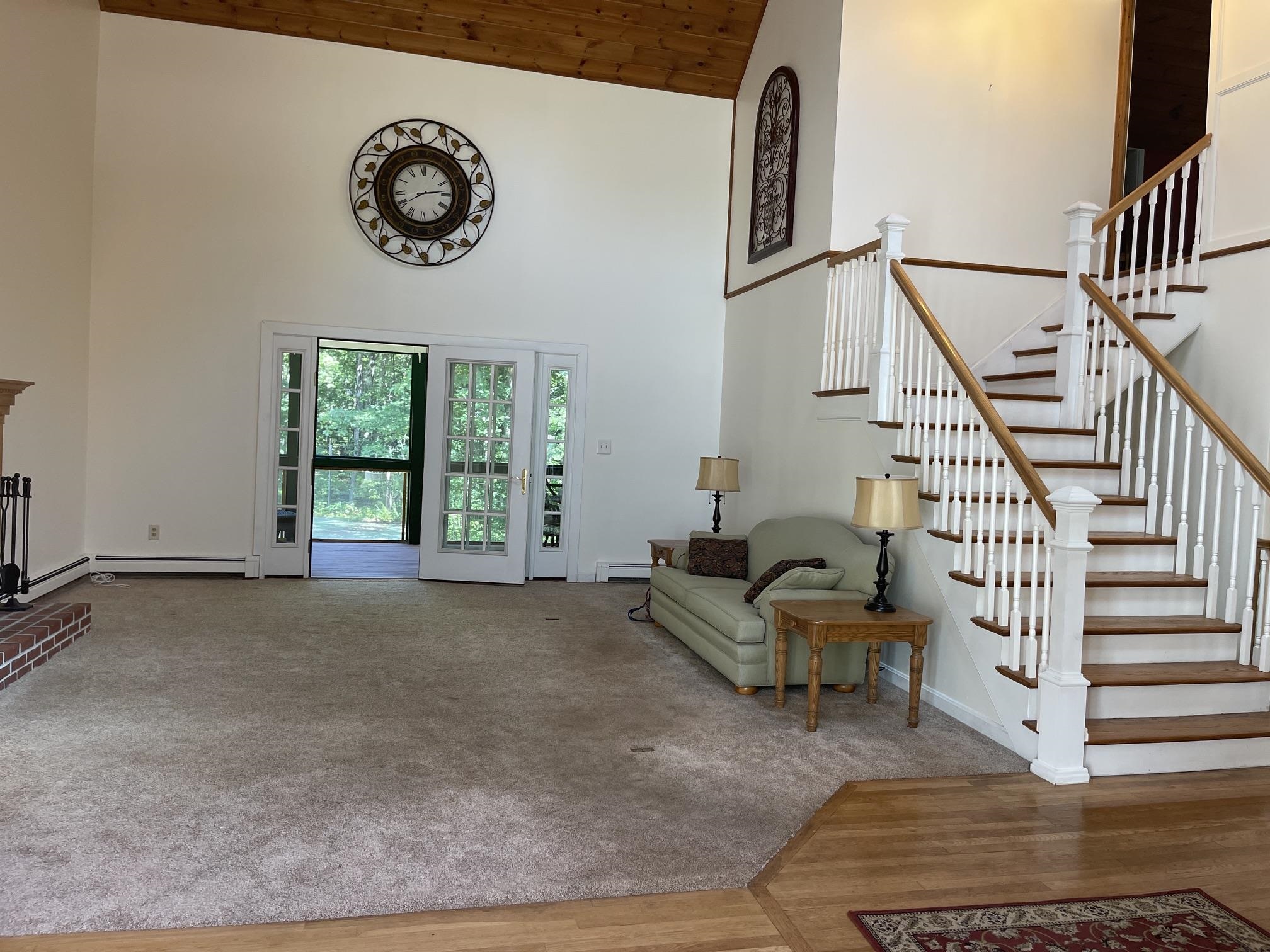 THE LIVING AREA HAS A VAULTED CEILING LOOKING TO THE STAIRWELL TO THE 2ND FLOOR.