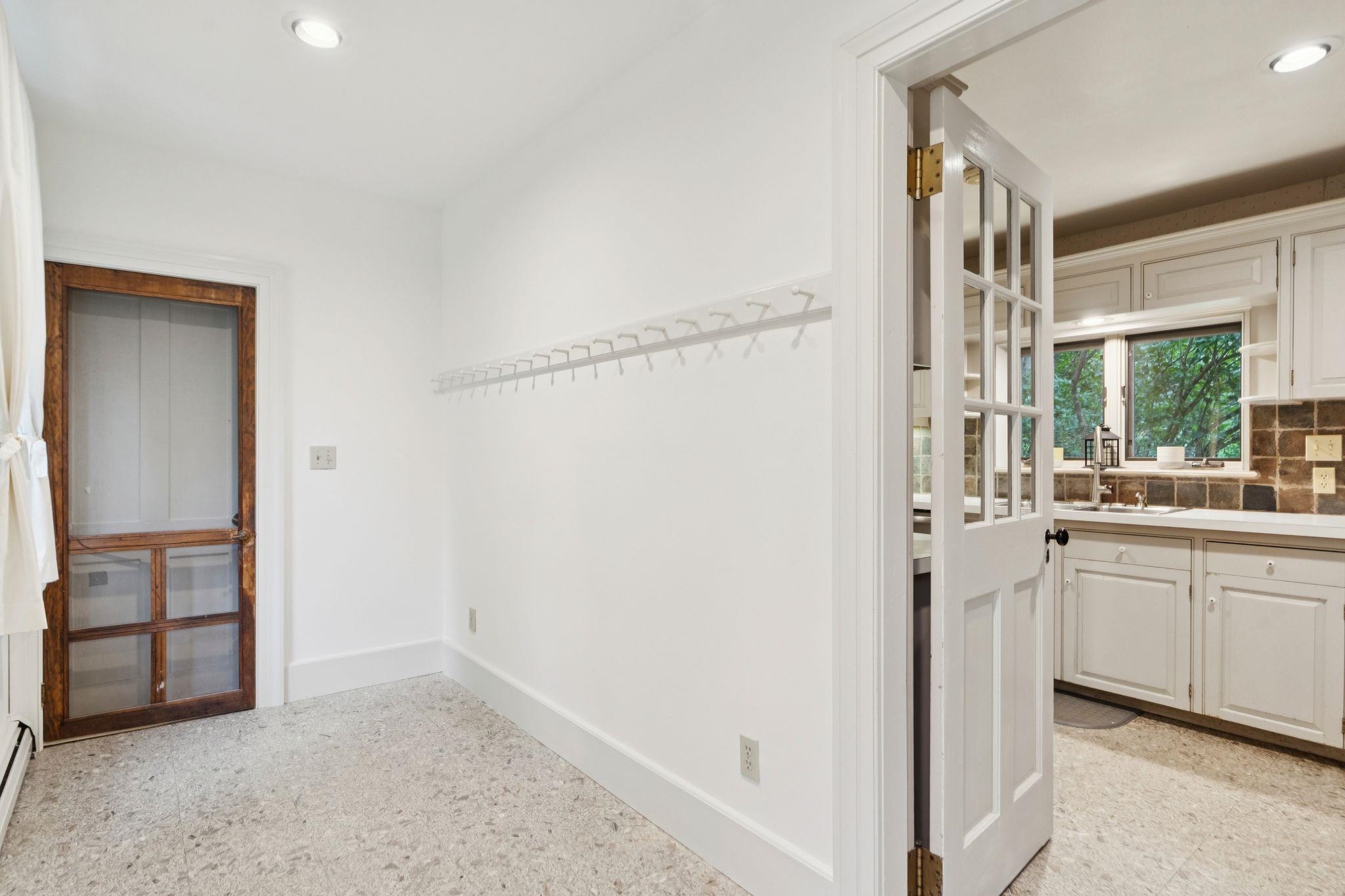 Unstaged mudroom w entrance to garage and kitchen