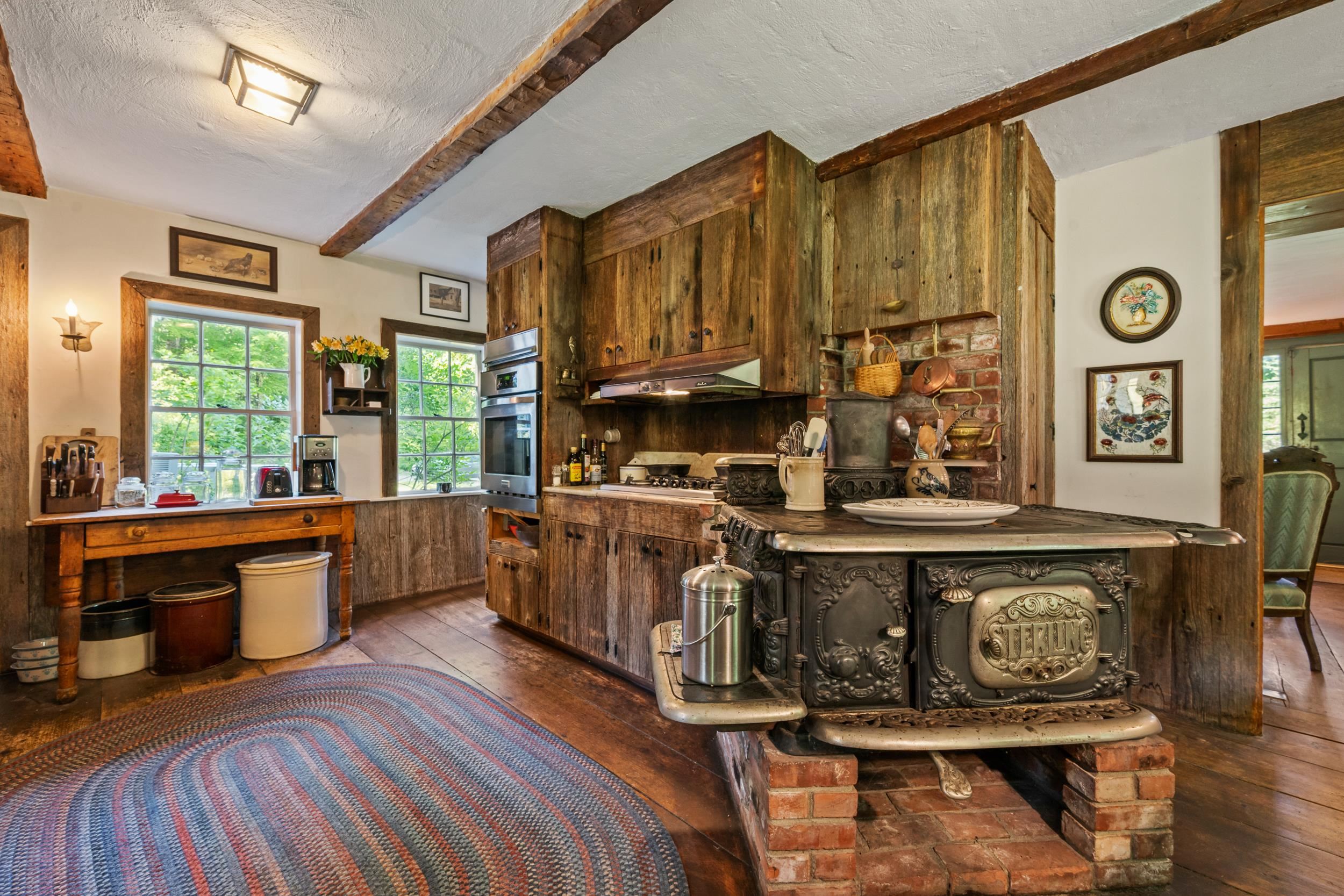 THERE IS A DECORATIVE ANTIQUE COOKSTOVE, AS WELL AS A MODERN GAS STOVE.