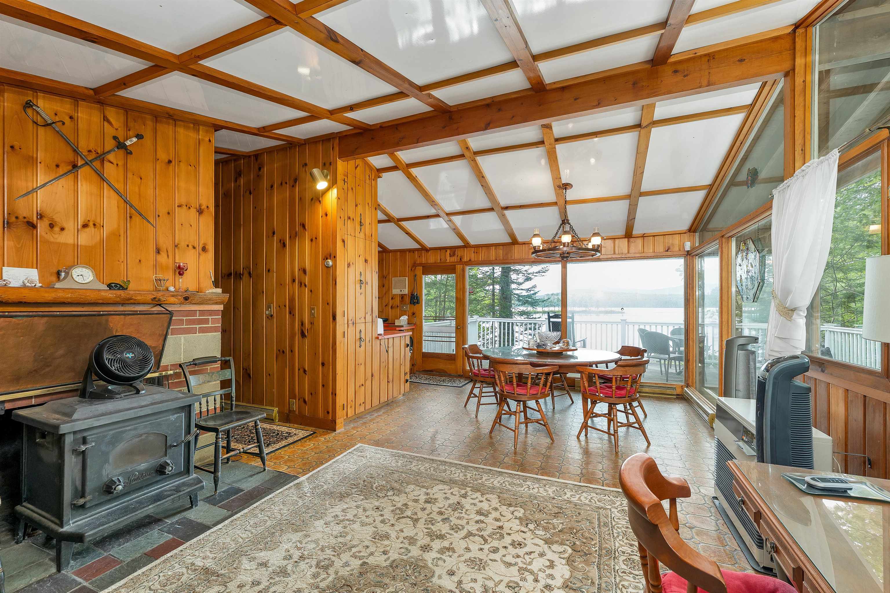 THERE IS A SECOND FIREPLACE WITH A WOODSTOVE AND MORE LARGE WINDOWS.