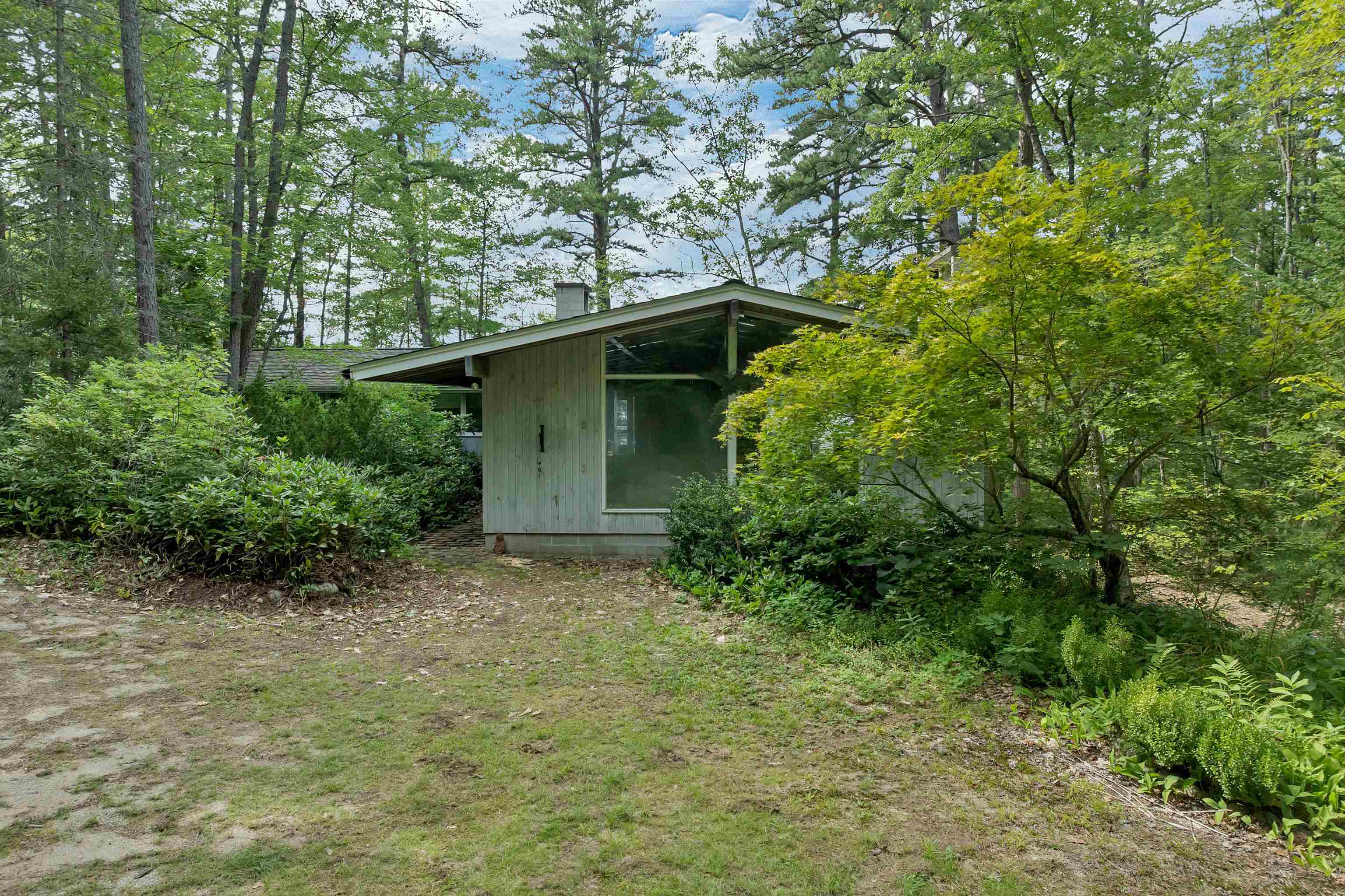THE HOUSE IS HIDDEN IN THE WOODS AND BUSHES AT THE END OF THE DRIVEWAY.