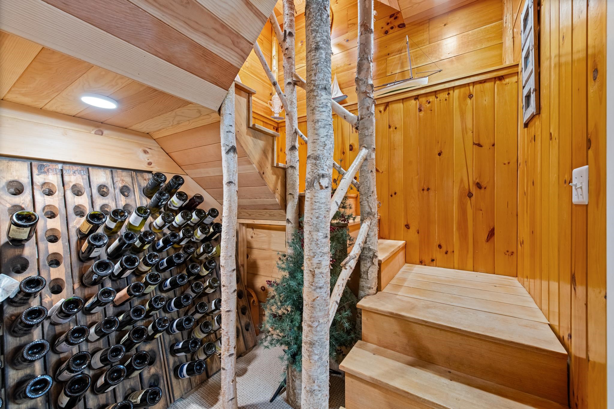 Wine racks at the base of the custom beautiful birch tree stairwell