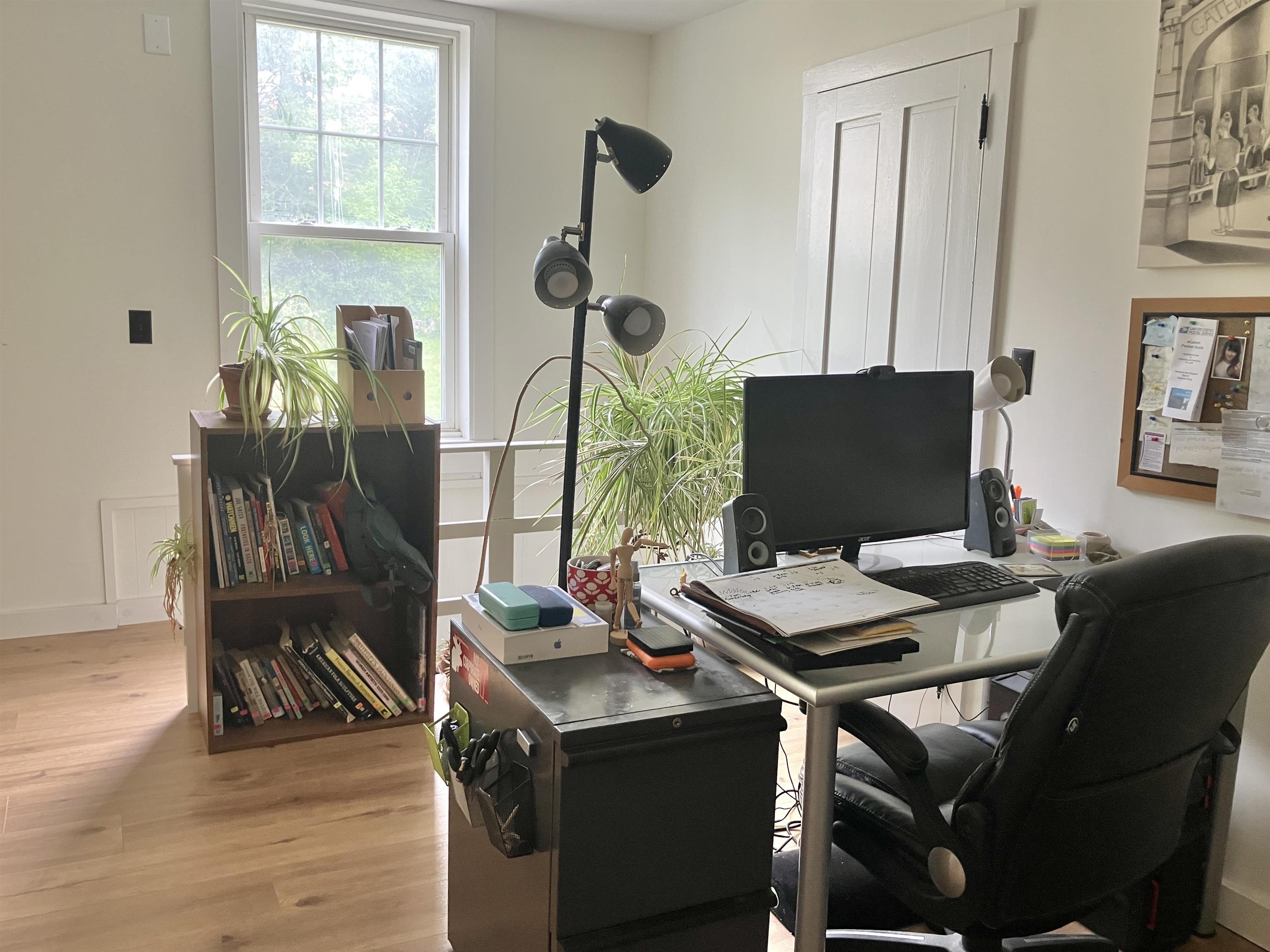 This light-filled walk through bedroom, currently used as an office, is off the kitchen stairway