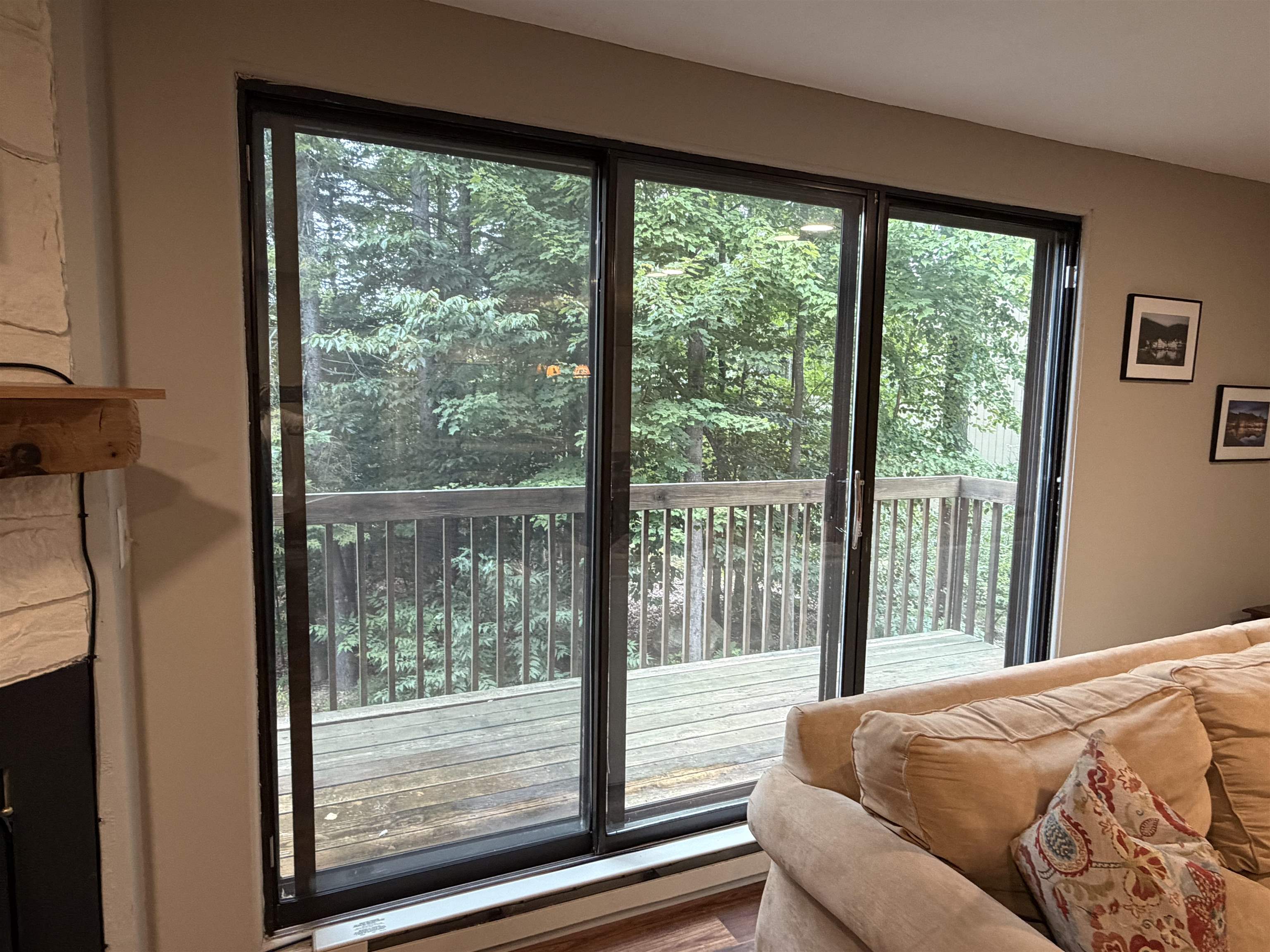 Sliding glass door leads to large deck overlooking trees